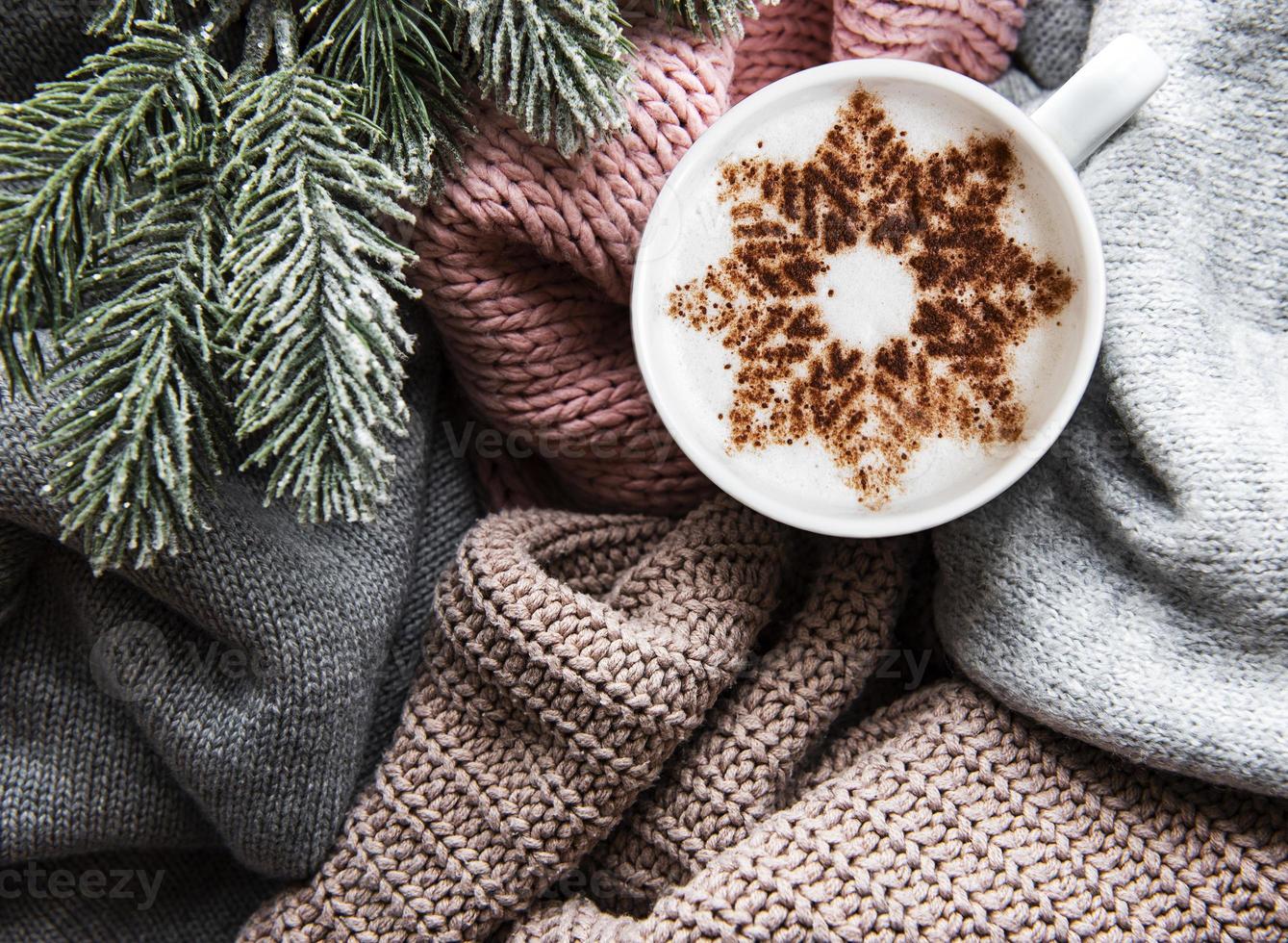 Coffee with a snowflake pattern on a warm knitted sweaters photo