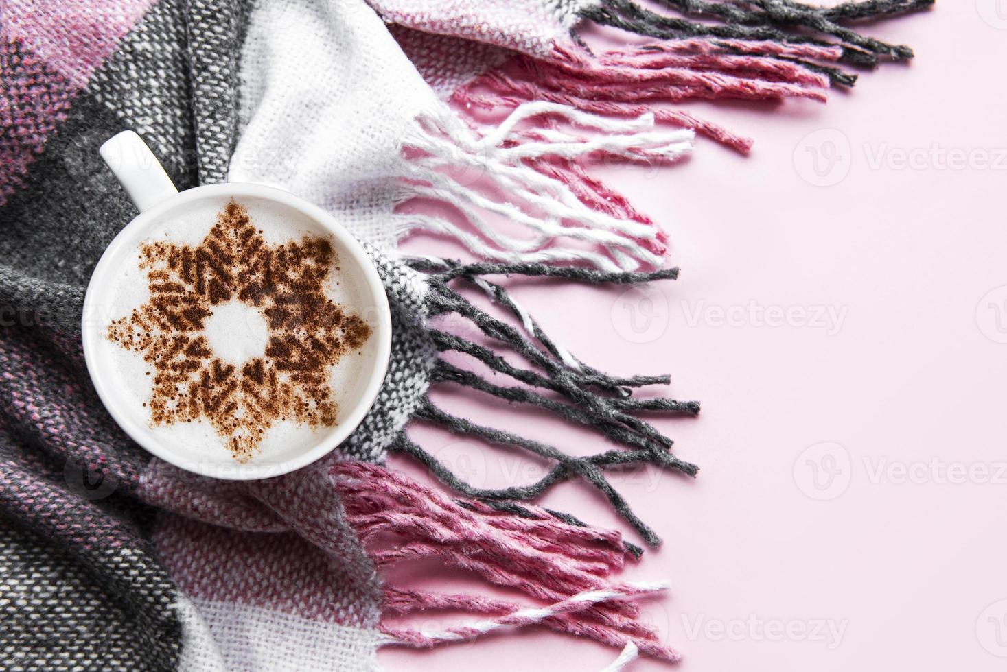 Coffee with a snowflake pattern on a warm woolen plaid photo