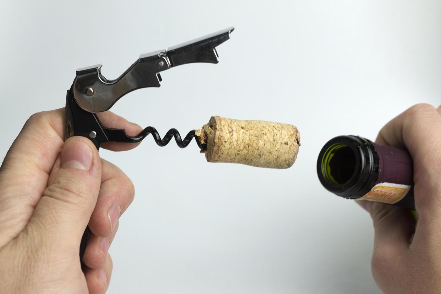The hand holding the corkscrew on white background for wine bottles. photo