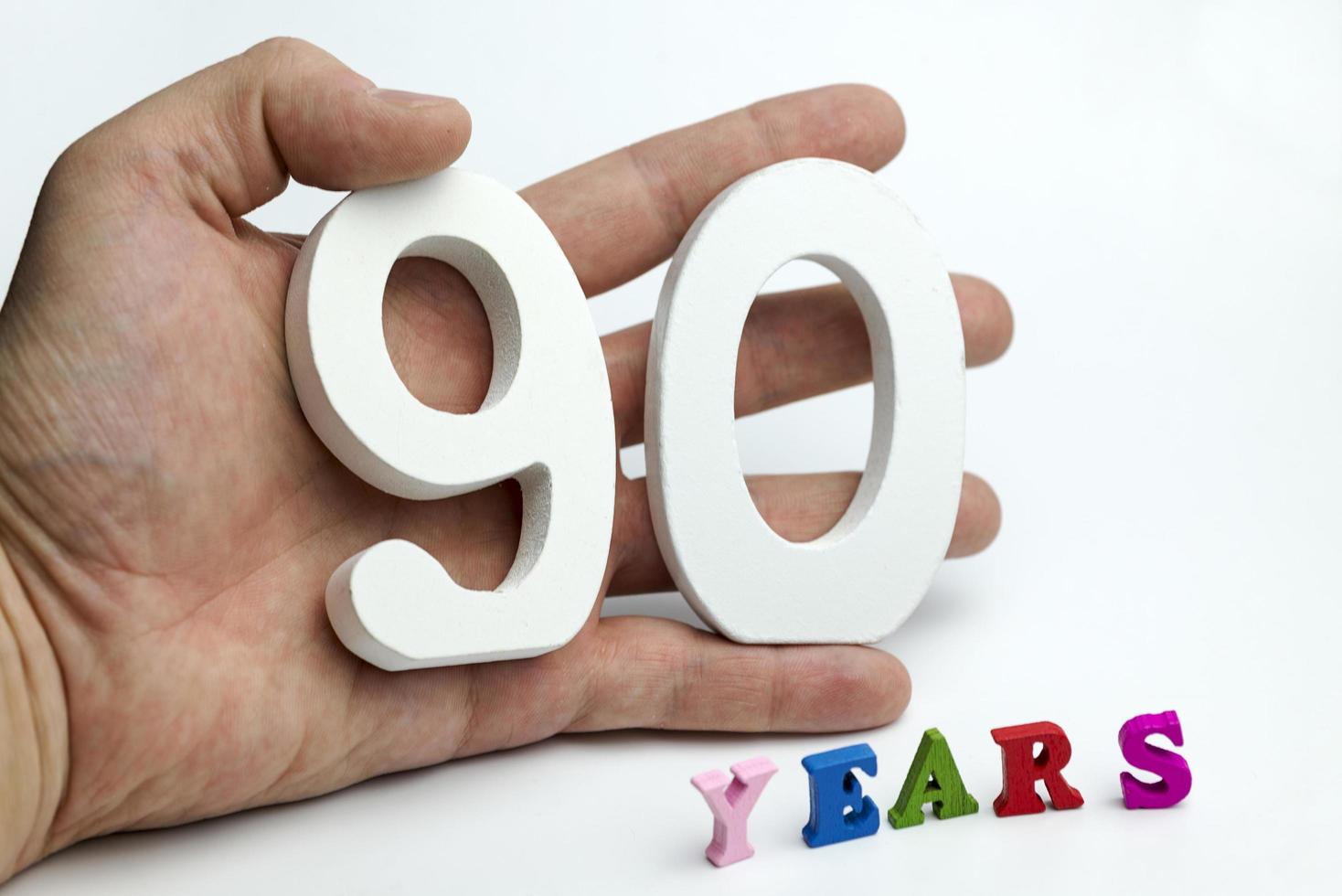 Hand holds a number ninety. photo