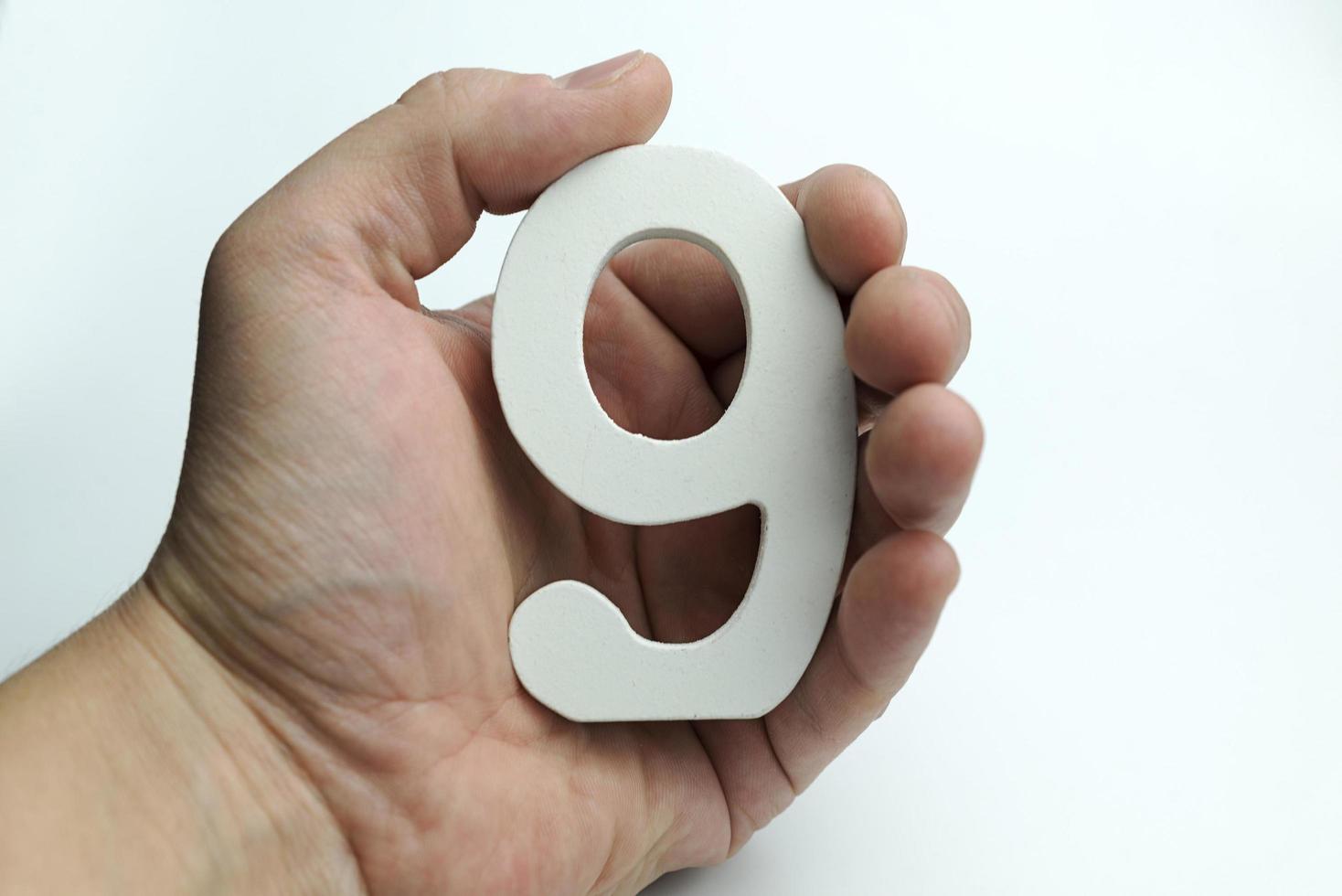Hand holding number nine. photo
