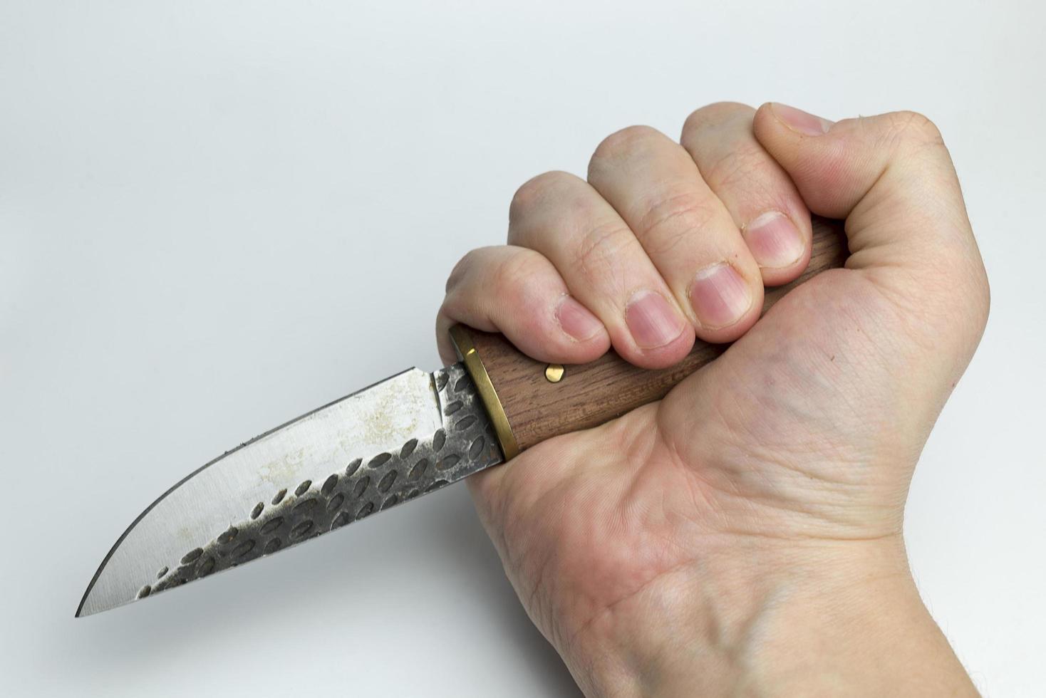 mano sobre un fondo blanco sosteniendo un cuchillo. foto