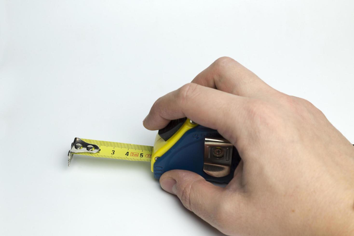 Hand on a white background holding a tape measure. photo