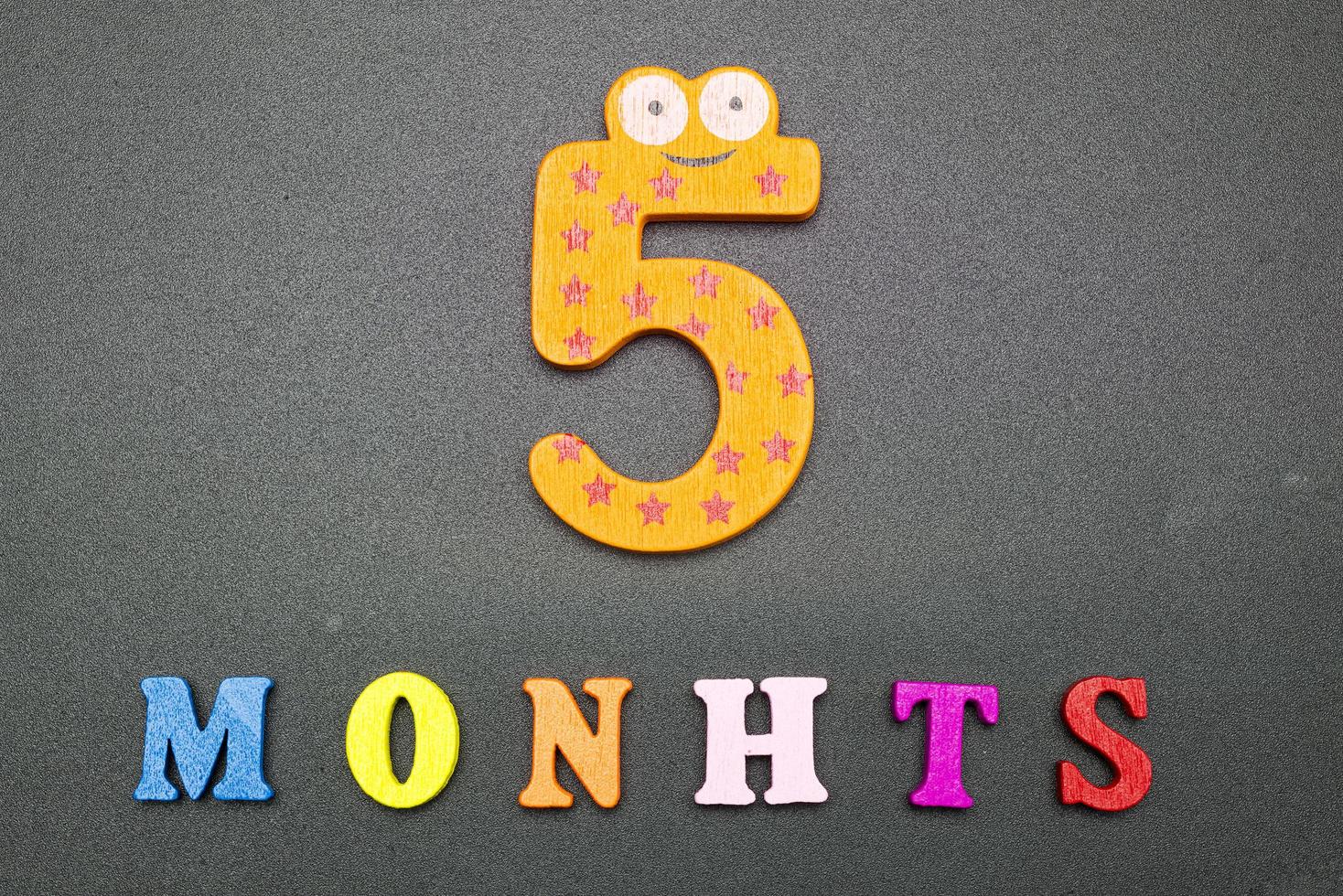 Five months on a black background. photo