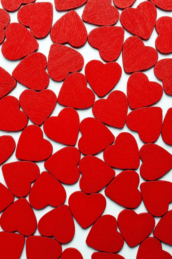 A lot of red hearts lying on the white background. photo