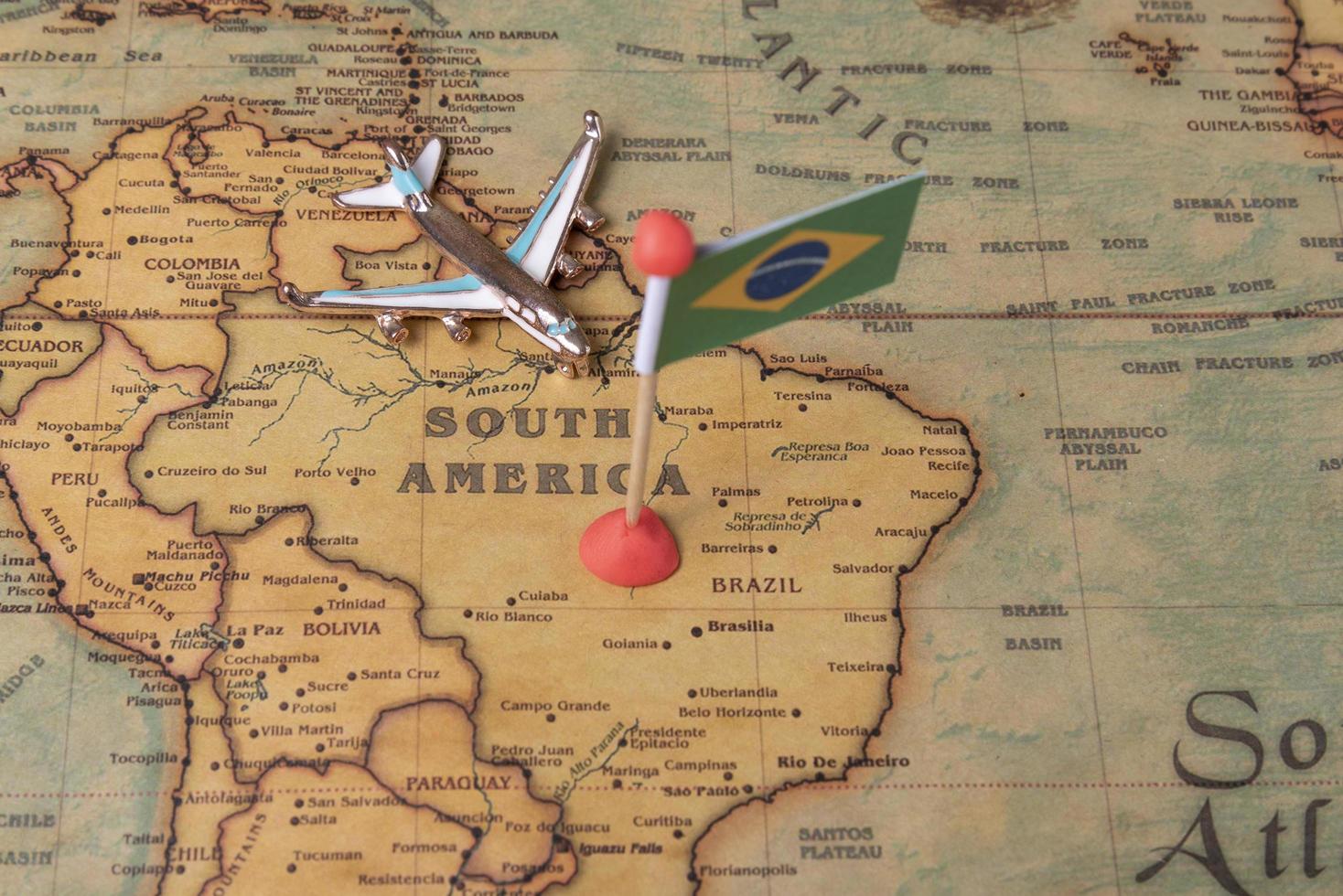 la bandera de brasil y el avión en el mapa mundial. foto