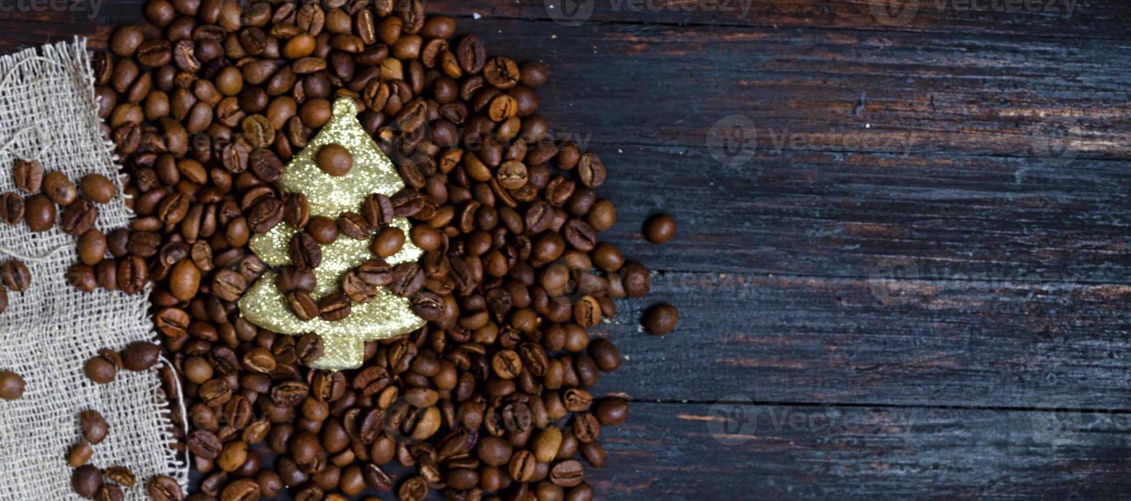 un árbol de navidad de juguete en granos de café sobre un fondo de madera, vista superior. foto