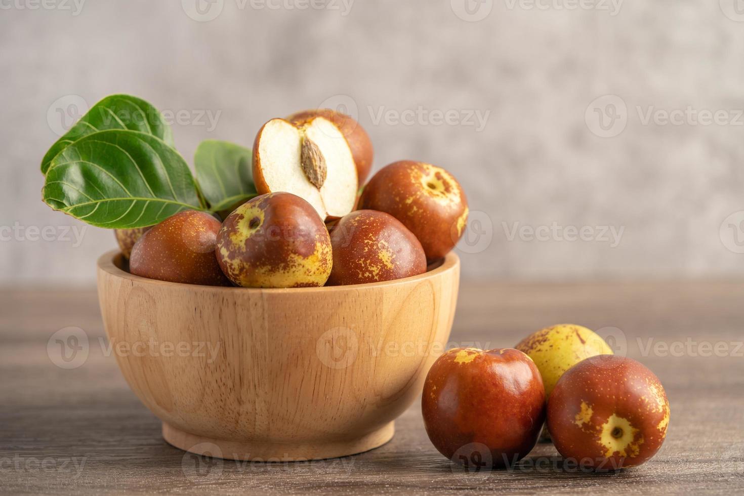 Jujube fruit or Chinese Dates in wooden bowl, healthy food. photo