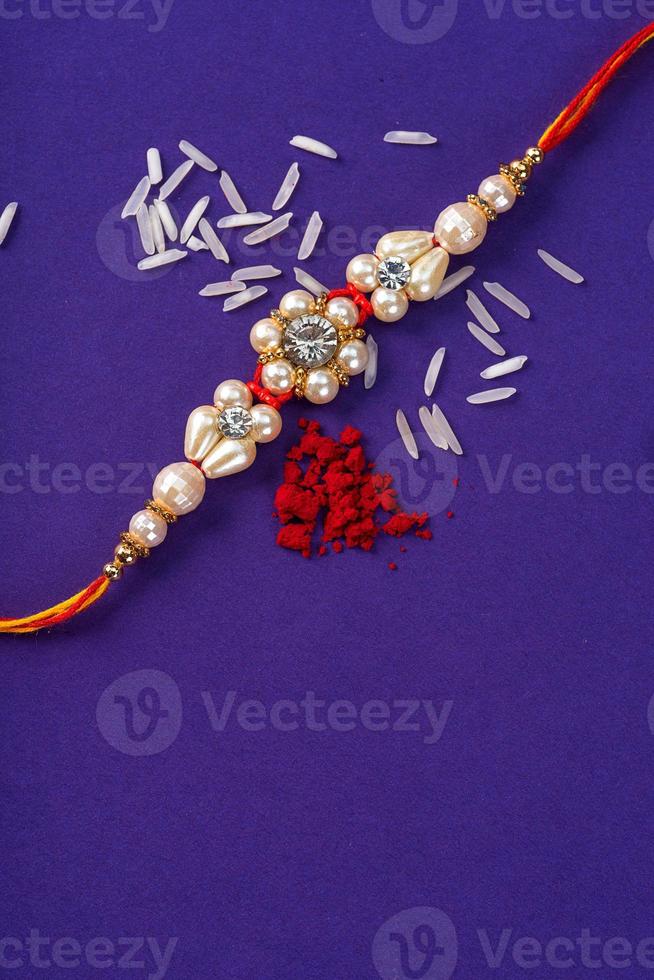 Raksha Bandhan Rakhi with rice grains and kumkum. An Indian festive background. Traditional Indian wrist band which is a symbol of love between Brothers and Sisters. photo