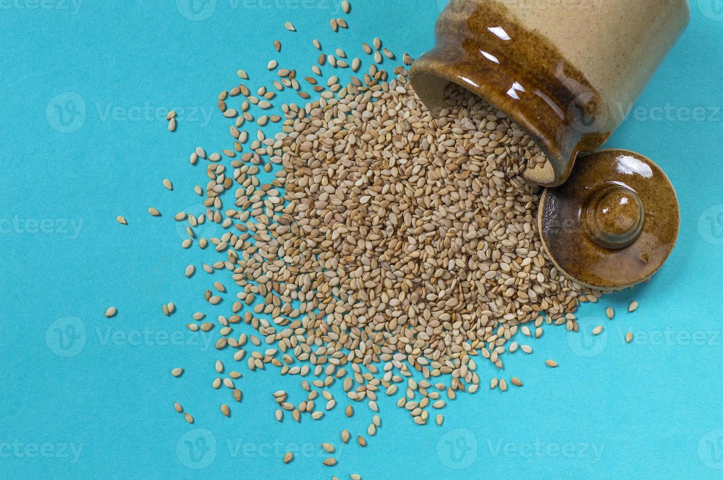 Sesame Seeds in pot on blue background photo