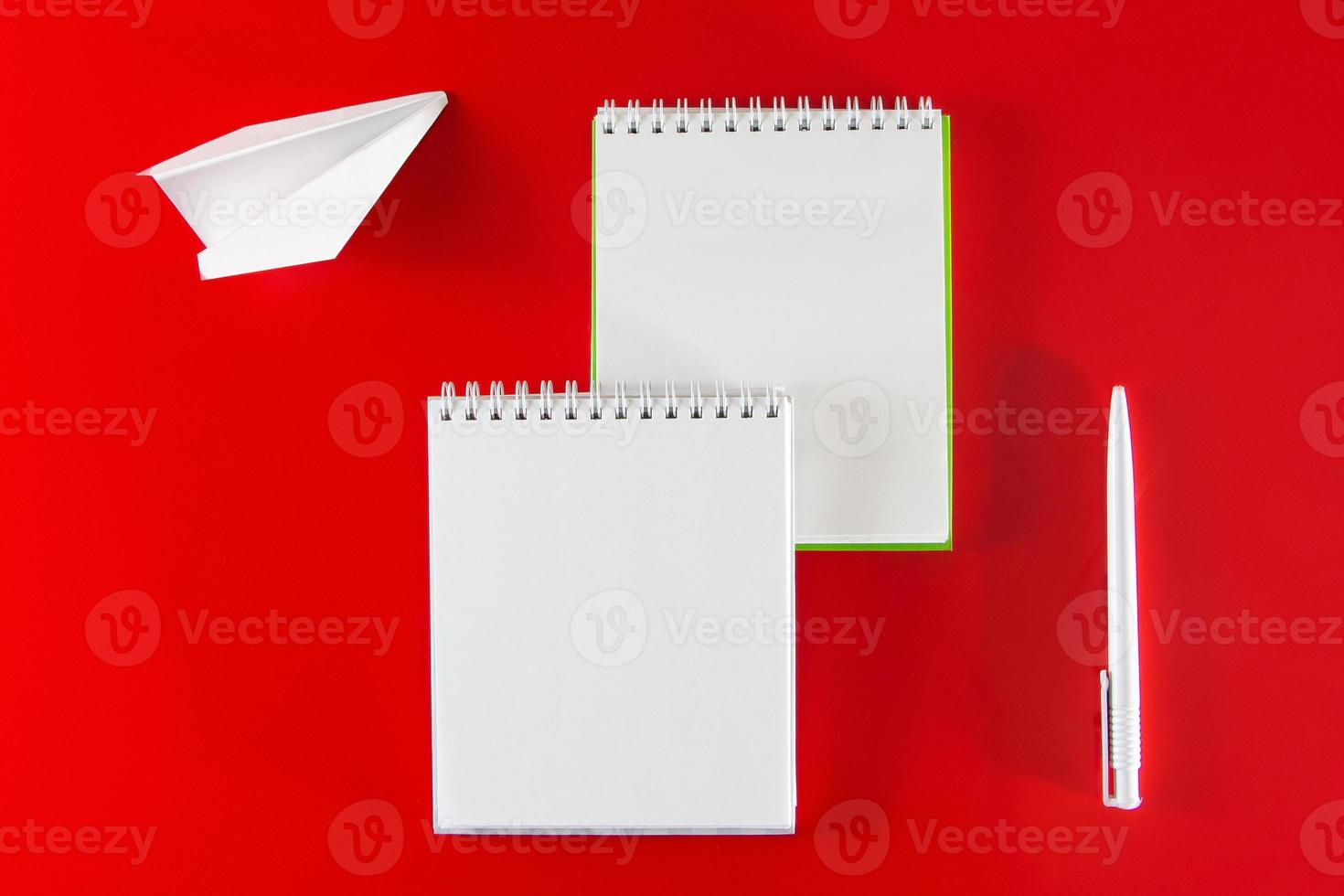 Office supplies on a red background. Blank notebook photo