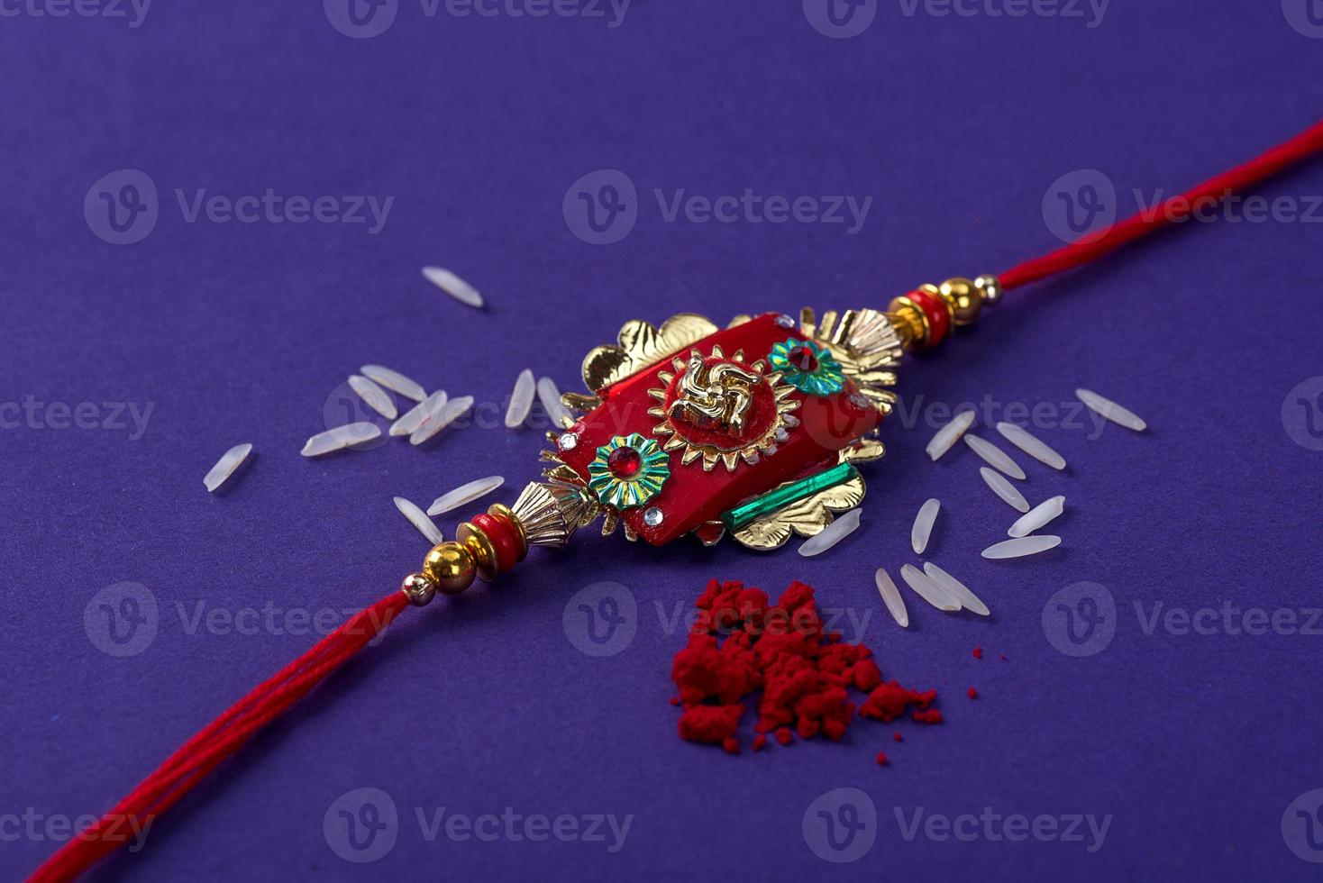 raksha bandhan rakhi con granos de arroz y kumkum. un fondo festivo indio. muñequera india tradicional que es un símbolo del amor entre hermanos y hermanas. foto