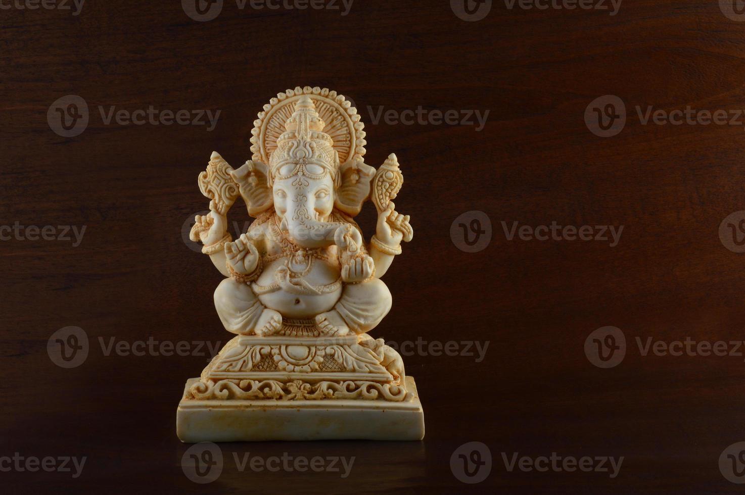 Hindu God Ganesha. Ganesha Idol on brown background photo