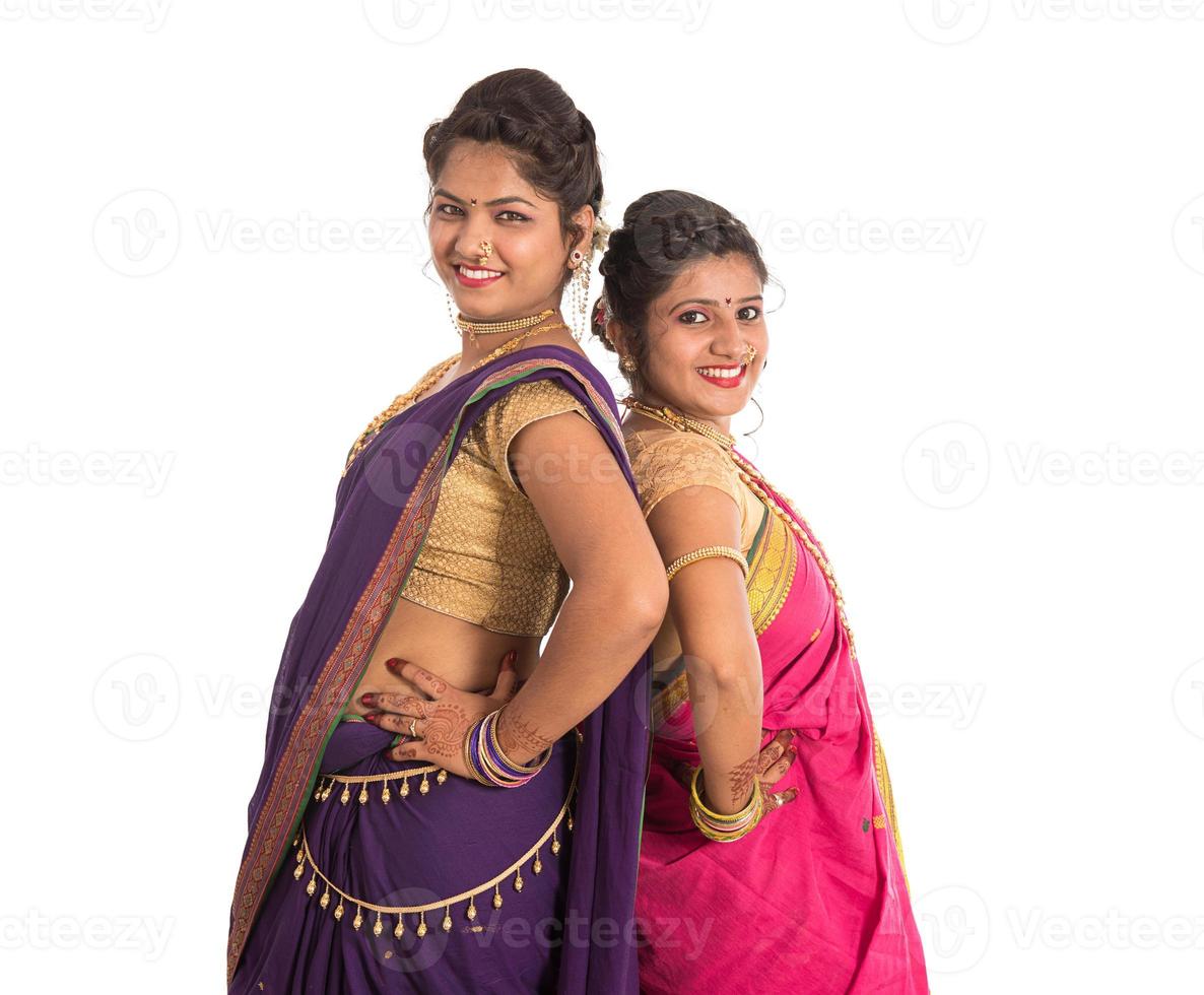 Hermosas niñas indias tradicionales en sari posando sobre fondo blanco. foto