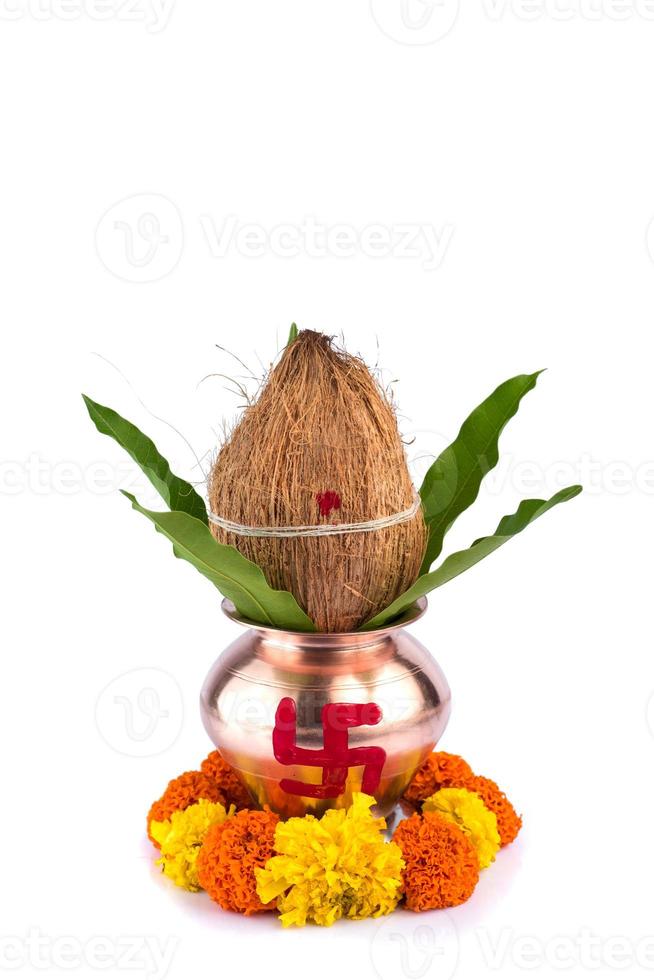 kalash de cobre con hoja de coco y mango y pooja thali con diya, kumkum y dulces con decoración floral sobre fondo blanco. esencial en puja hindú. foto