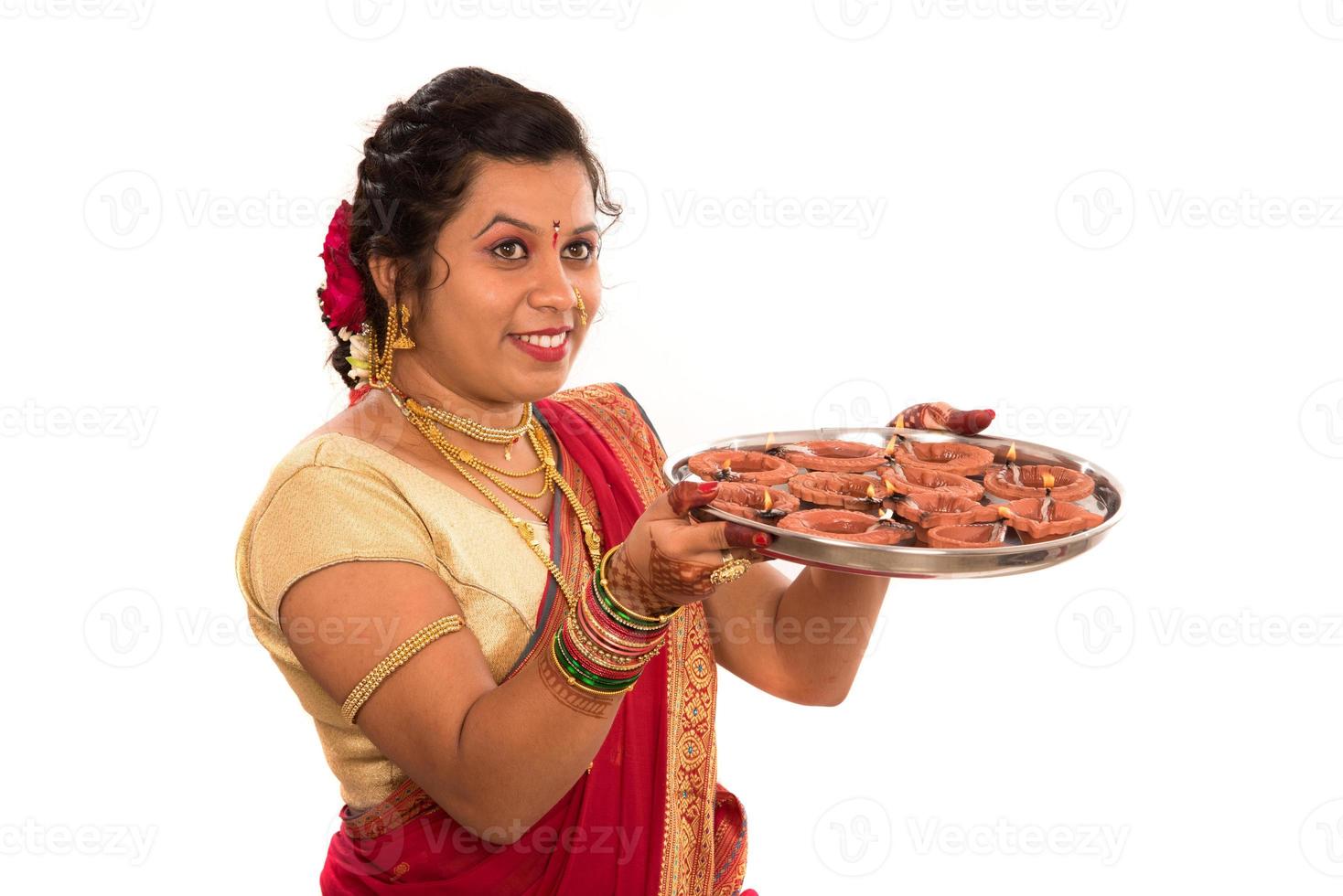 Portrait of a Indian Traditional Girl holding diya, Diwali or deepavali photo with female hands holding oil lamp during festival of light on white background