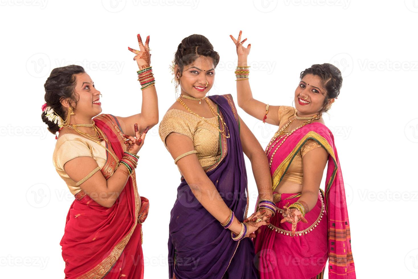 Hermosas niñas indias tradicionales en sari posando sobre fondo blanco. foto