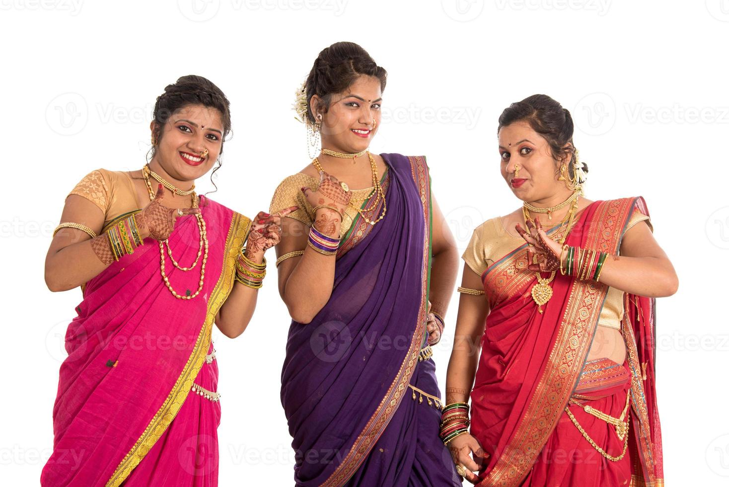 Hermosas niñas indias tradicionales en sari posando sobre fondo blanco. foto