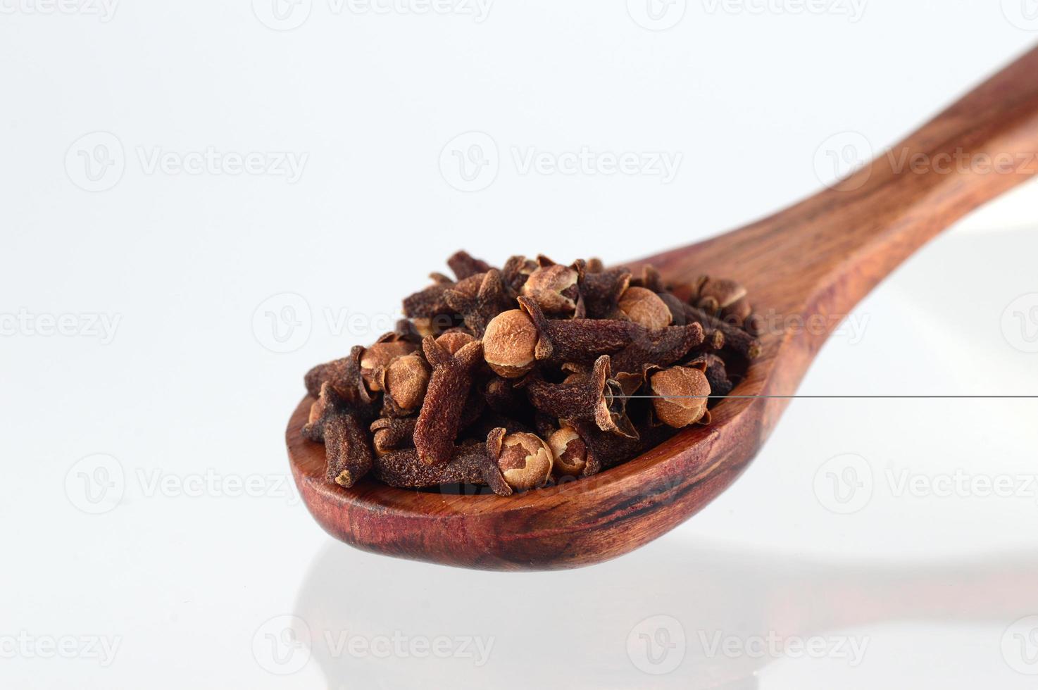 clove in spoon isolated on a white background photo