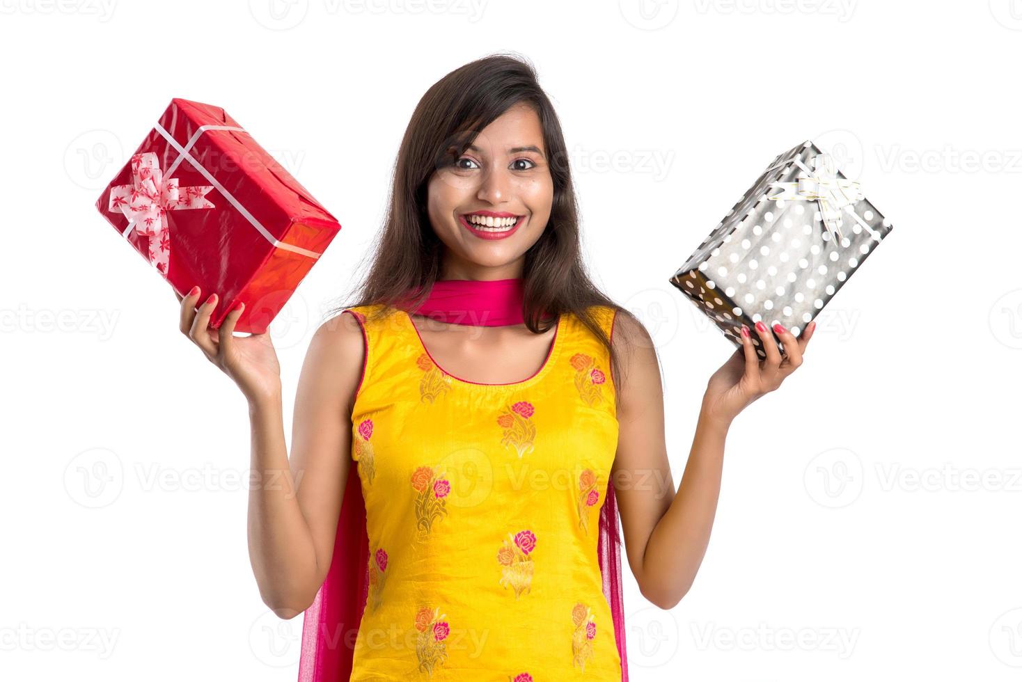 Retrato de joven india sonriente feliz sosteniendo cajas de regalo sobre un fondo blanco. foto