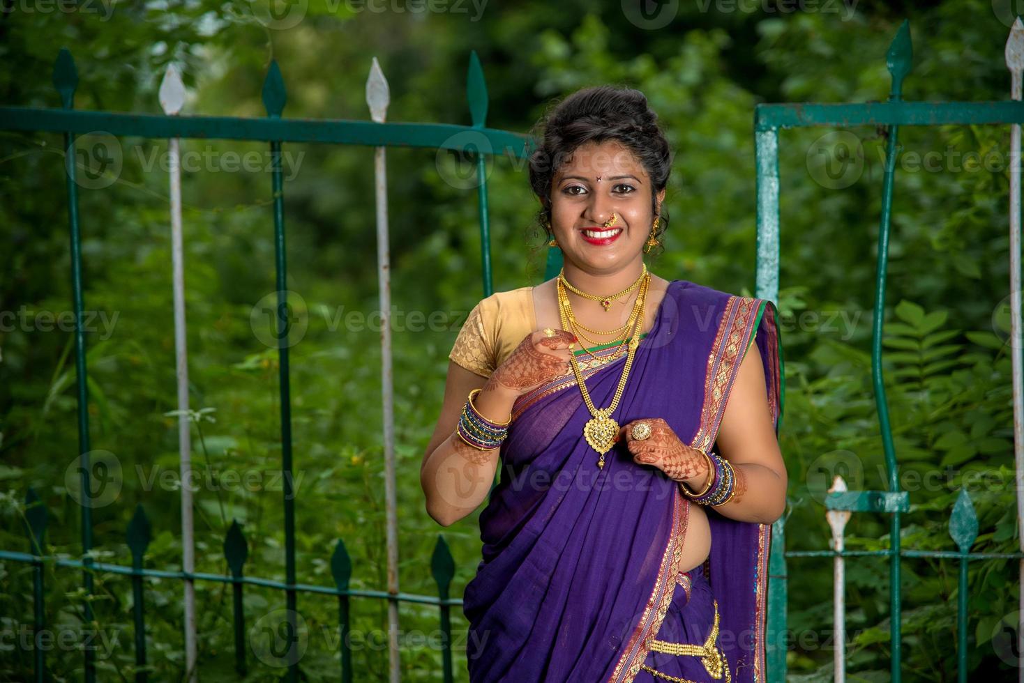 Hermosa joven india en sari tradicional posando al aire libre foto