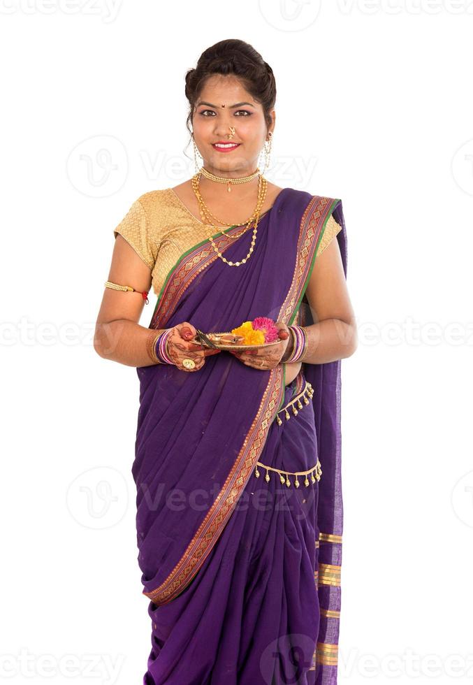 Retrato de una niña tradicional india sosteniendo pooja thali con foto diya, diwali o deepavali con manos femeninas sosteniendo una lámpara de aceite durante el festival de la luz sobre fondo blanco.