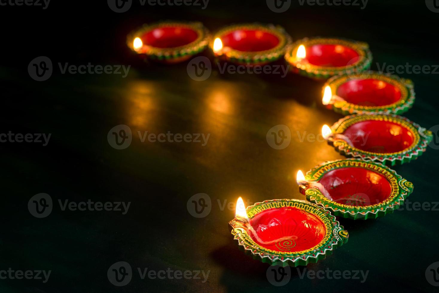 Happy Diwali - Clay Diya lamps lit during Diwali celebration. Greetings Card Design of Indian Hindu Light Festival called Diwali photo