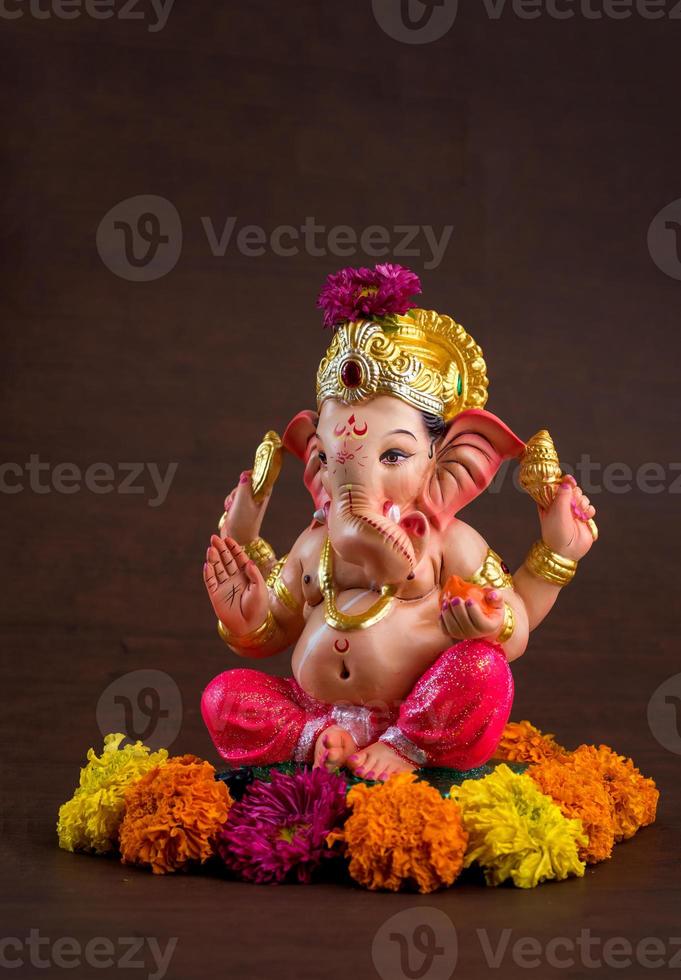 Hindu God Ganesha. Ganesha Idol on dark wooden background. photo