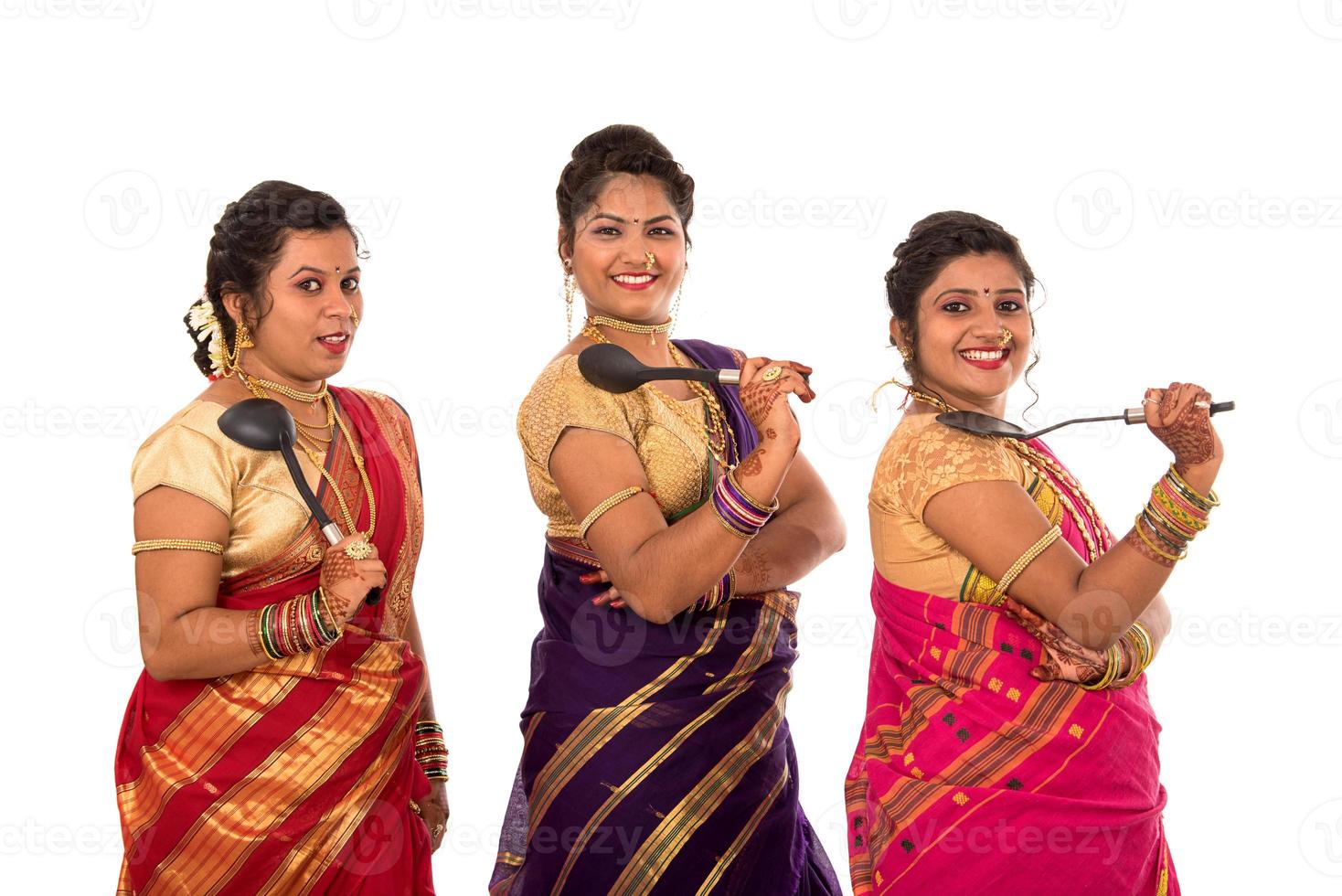 Young Traditional Indian Girls holding kitchen utensil on white background photo