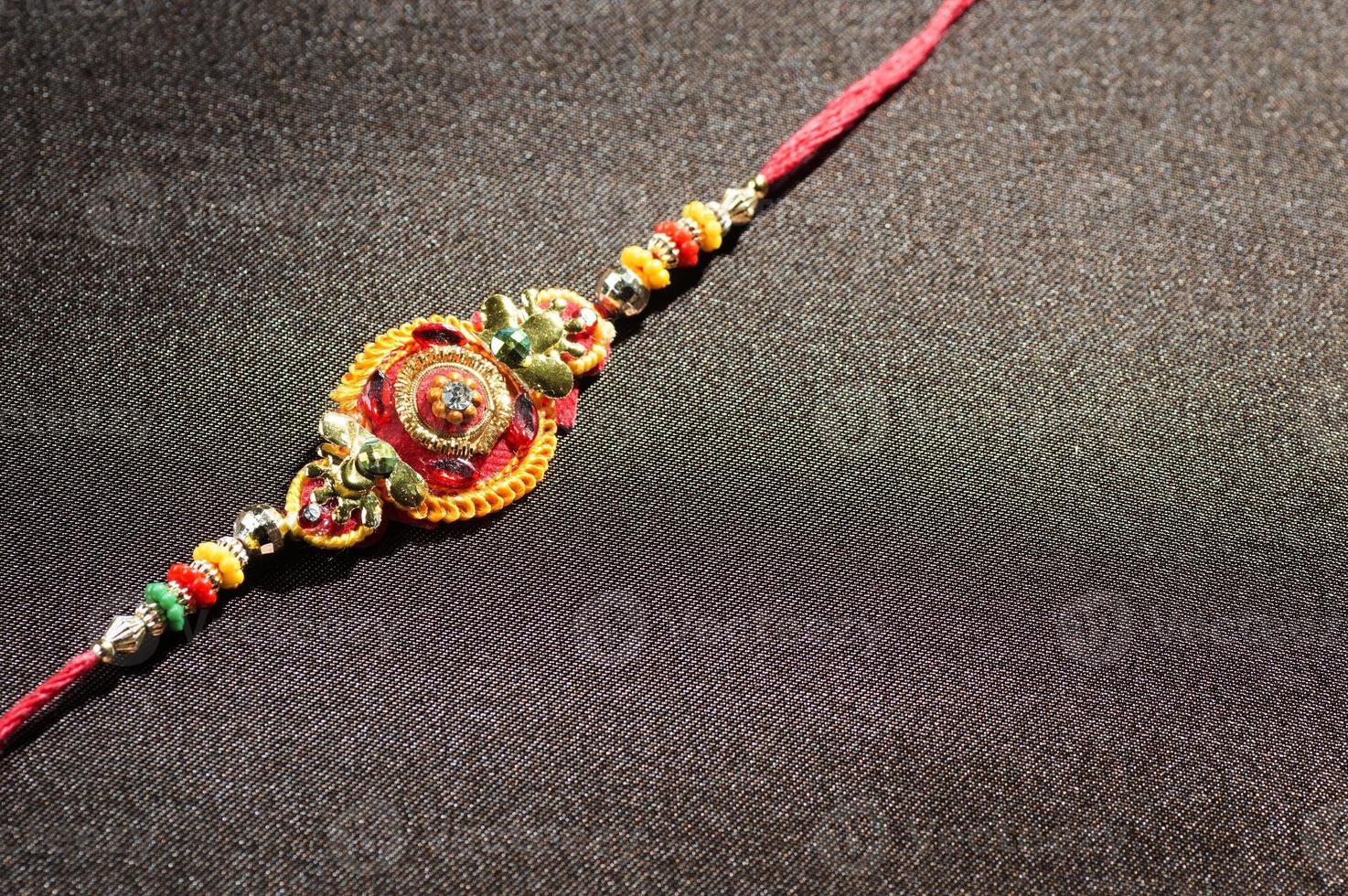 Raksha Bandhan background with an elegant Rakhi. A traditional Indian wrist band photo