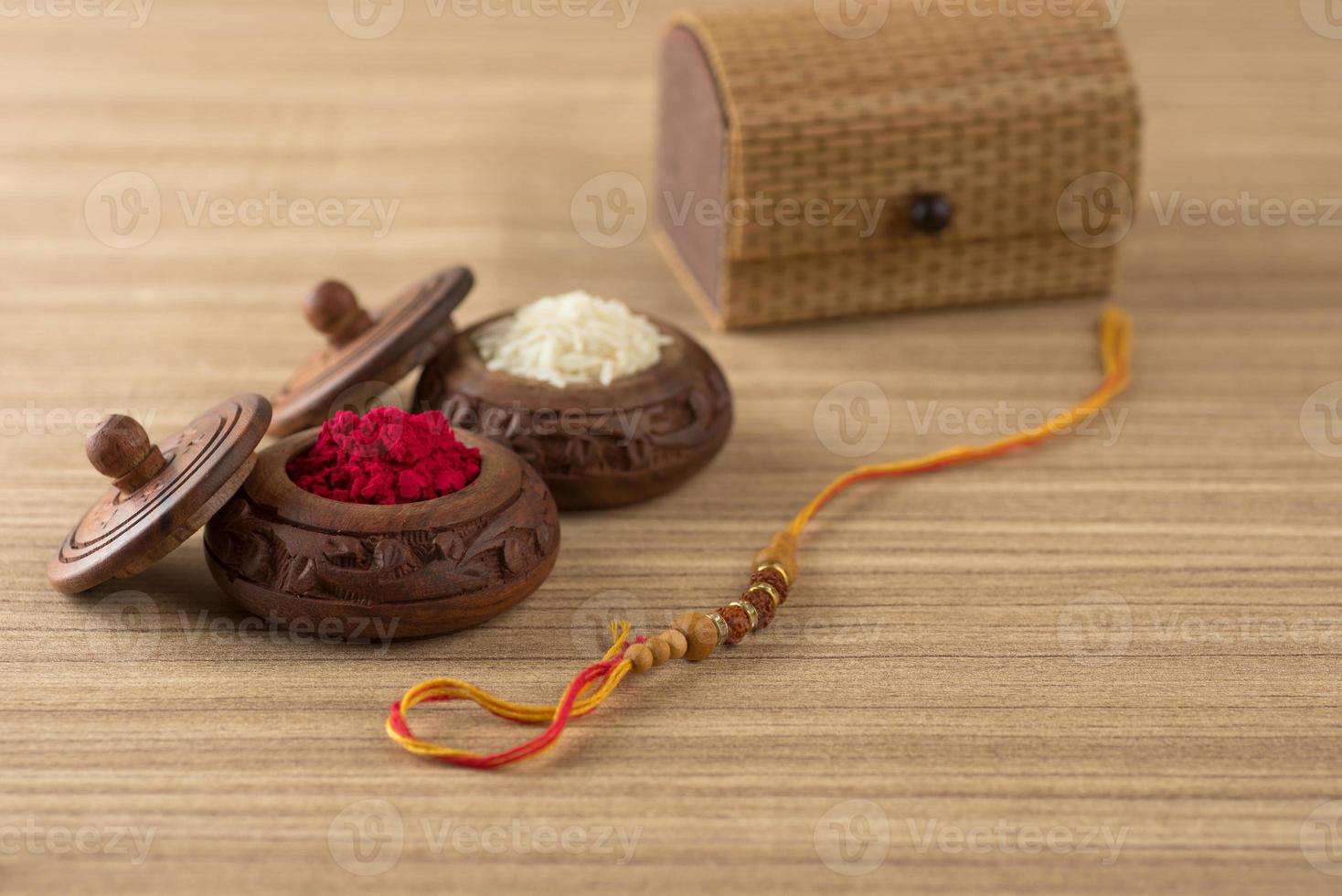 festival indio raksha bandhan de fondo con un elegante rakhi, granos de arroz y kumkum. una pulsera tradicional india que es un símbolo del amor entre hermanos y hermanas. foto