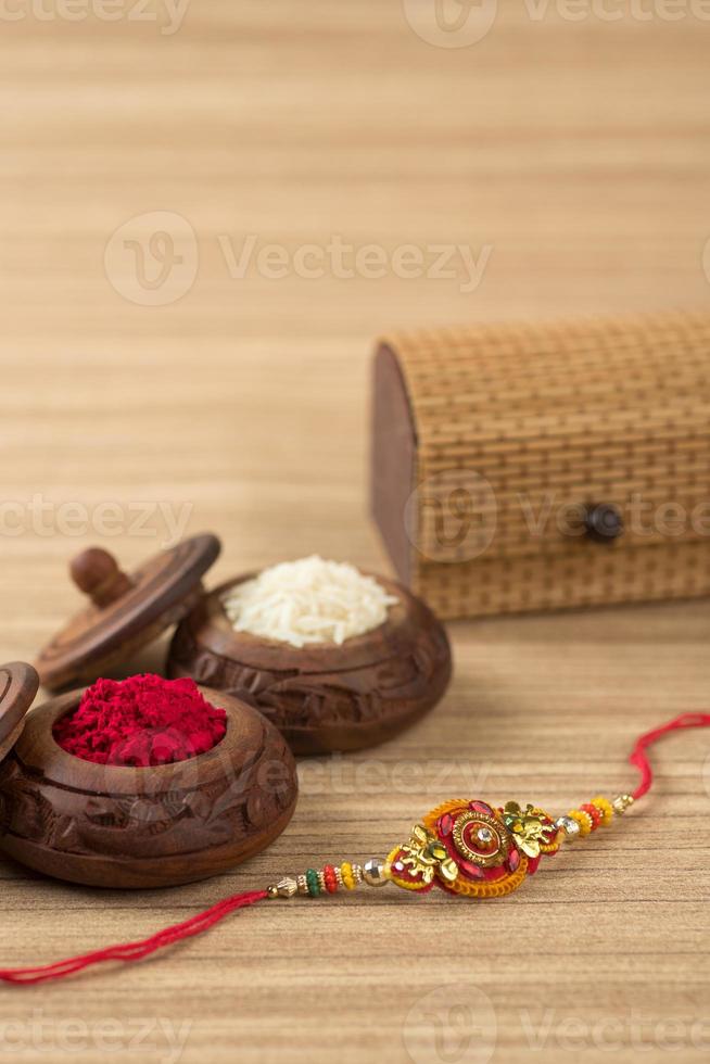 festival indio raksha bandhan de fondo con un elegante rakhi, granos de arroz y kumkum. una pulsera tradicional india que es un símbolo del amor entre hermanos y hermanas. foto