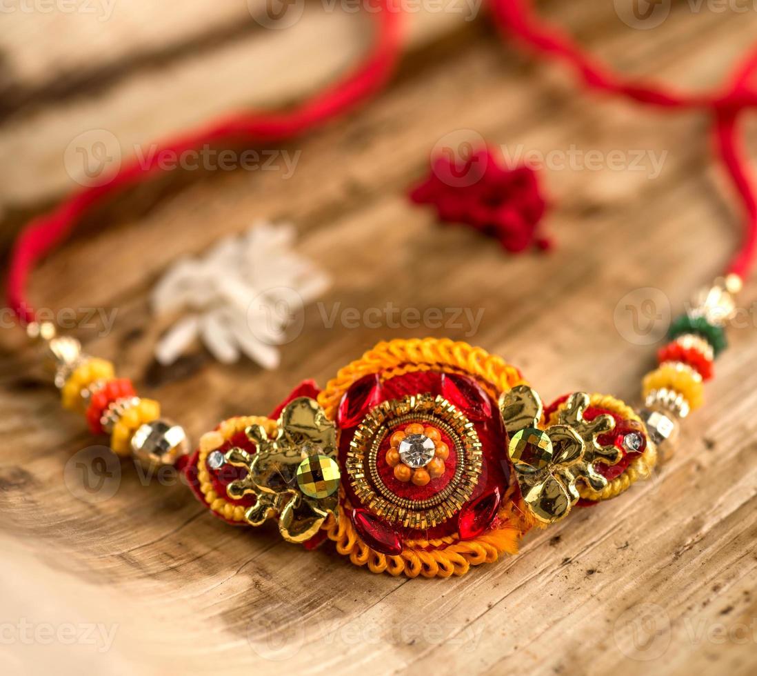 festival indio raksha bandhan de fondo con un elegante rakhi, granos de arroz y kumkum. una pulsera tradicional india que es un símbolo del amor entre hermanos y hermanas. foto