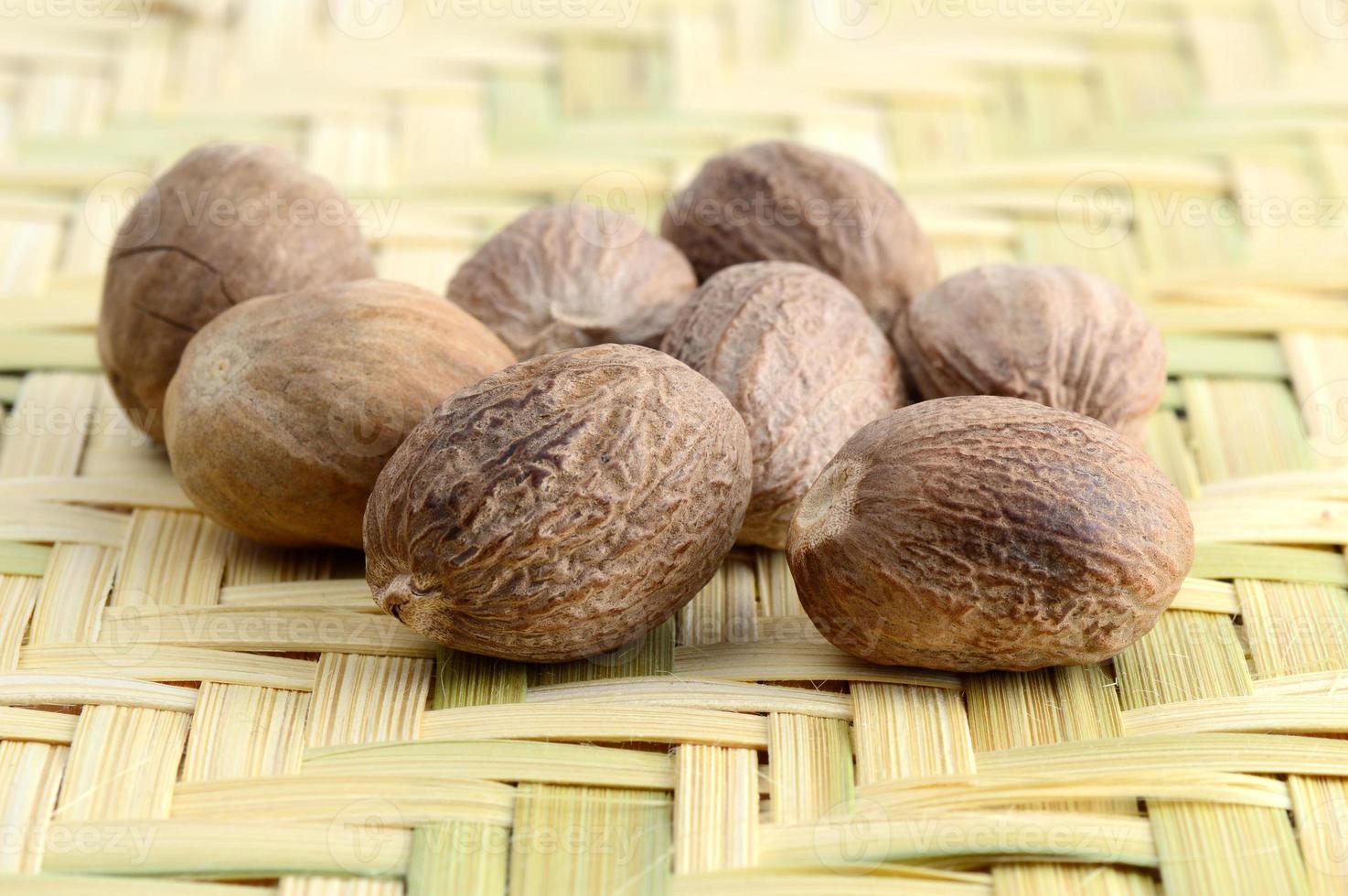 Nutmeg in bamboo basket isolated on white background photo