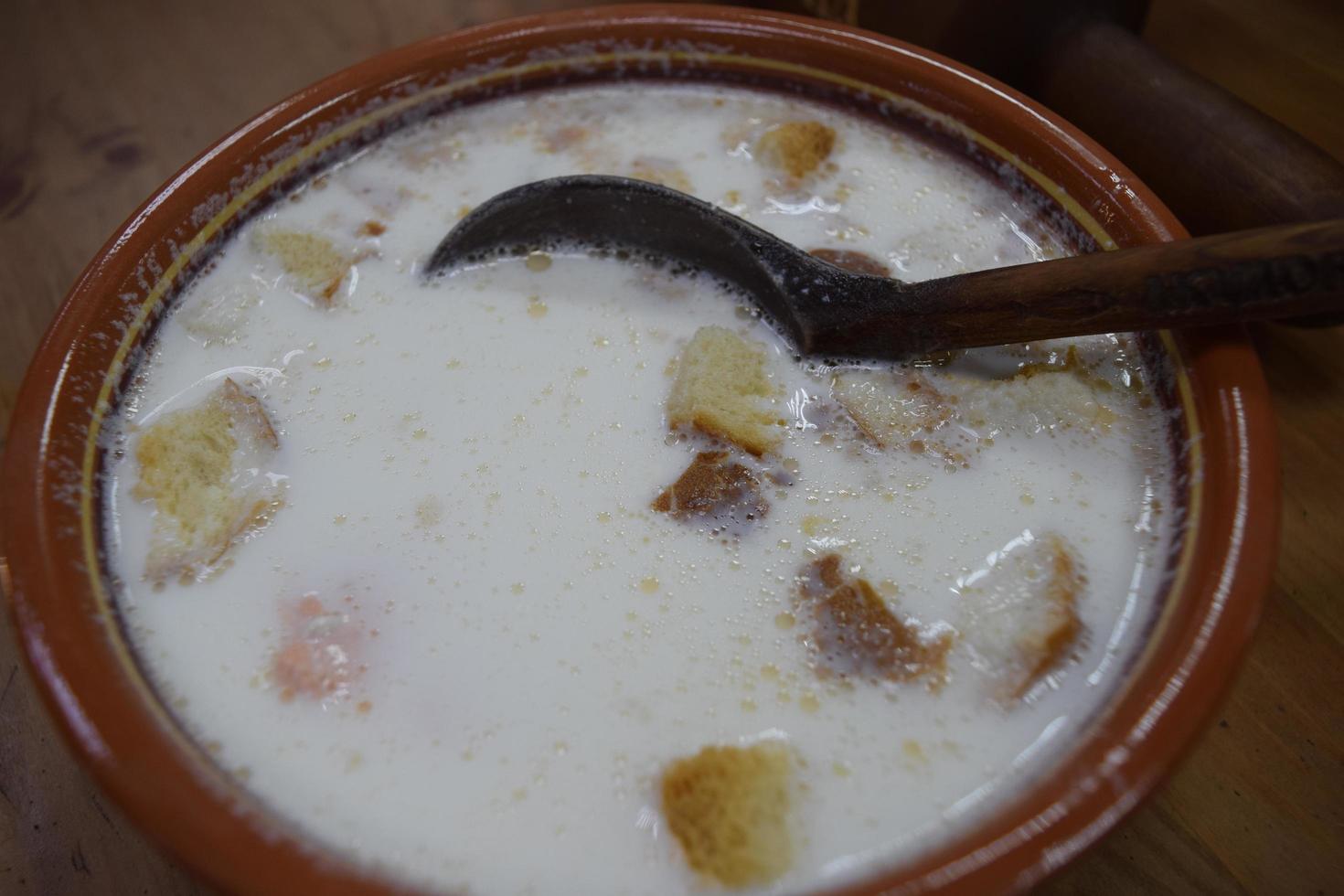 red fish soup with cream in a pot photo