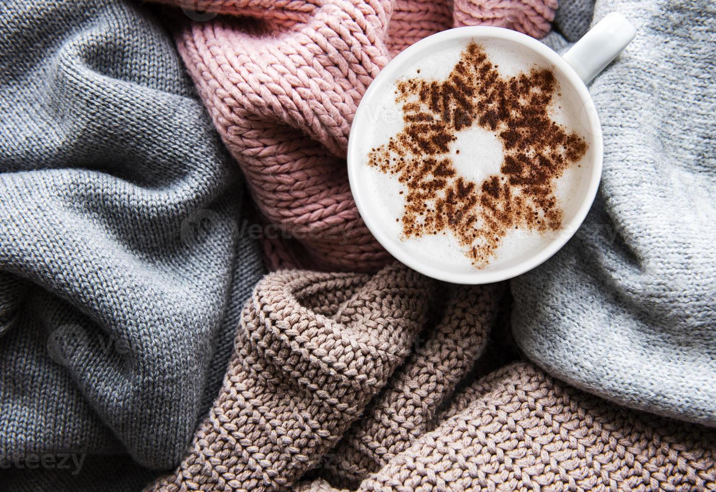 Coffee with a snowflake pattern on a warm knitted sweaters photo