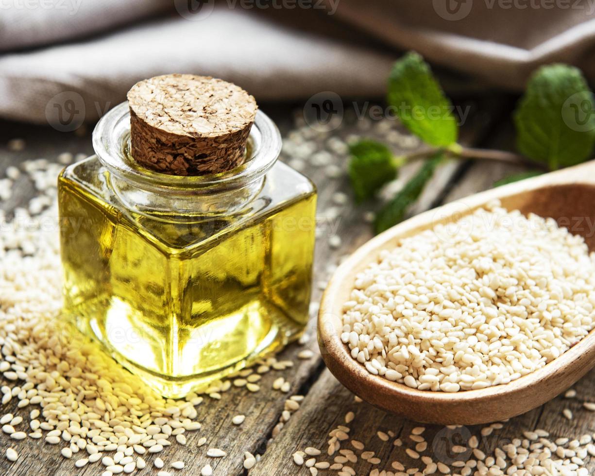 Sesame oil and seeds on a rustic table. photo