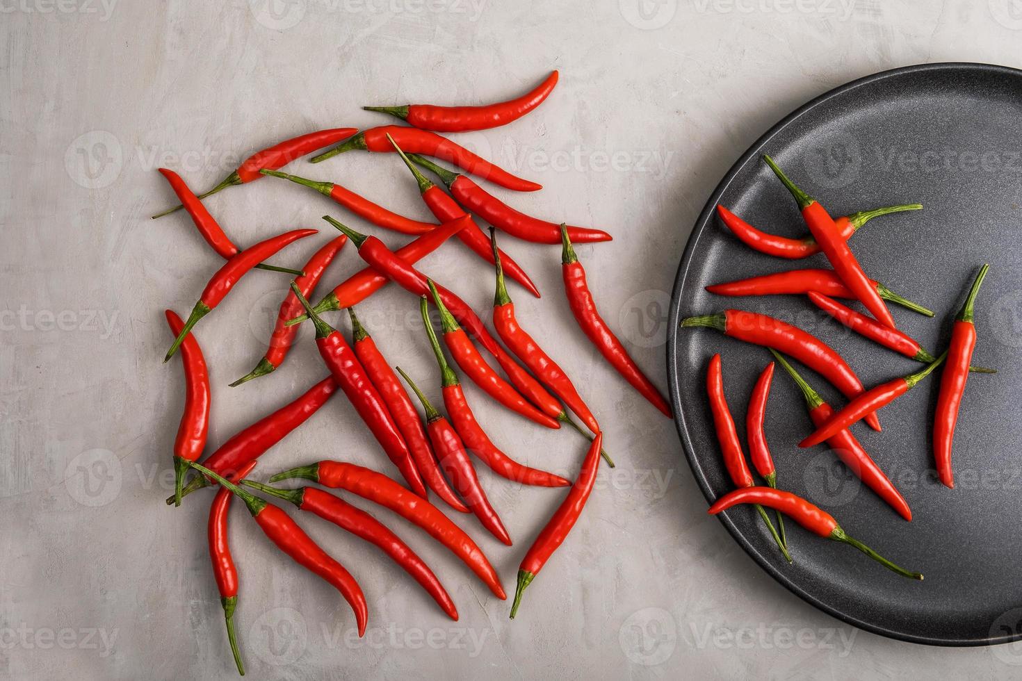 chiles rojos enteros dentro y al lado del plato negro foto