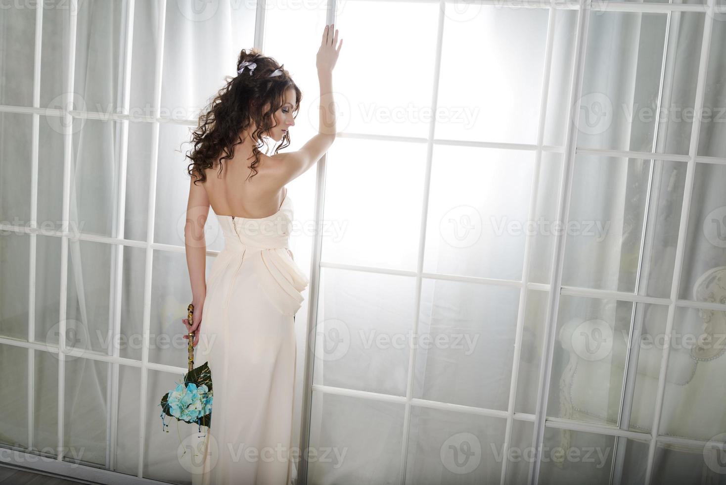 Girl in a white dress at the door. photo