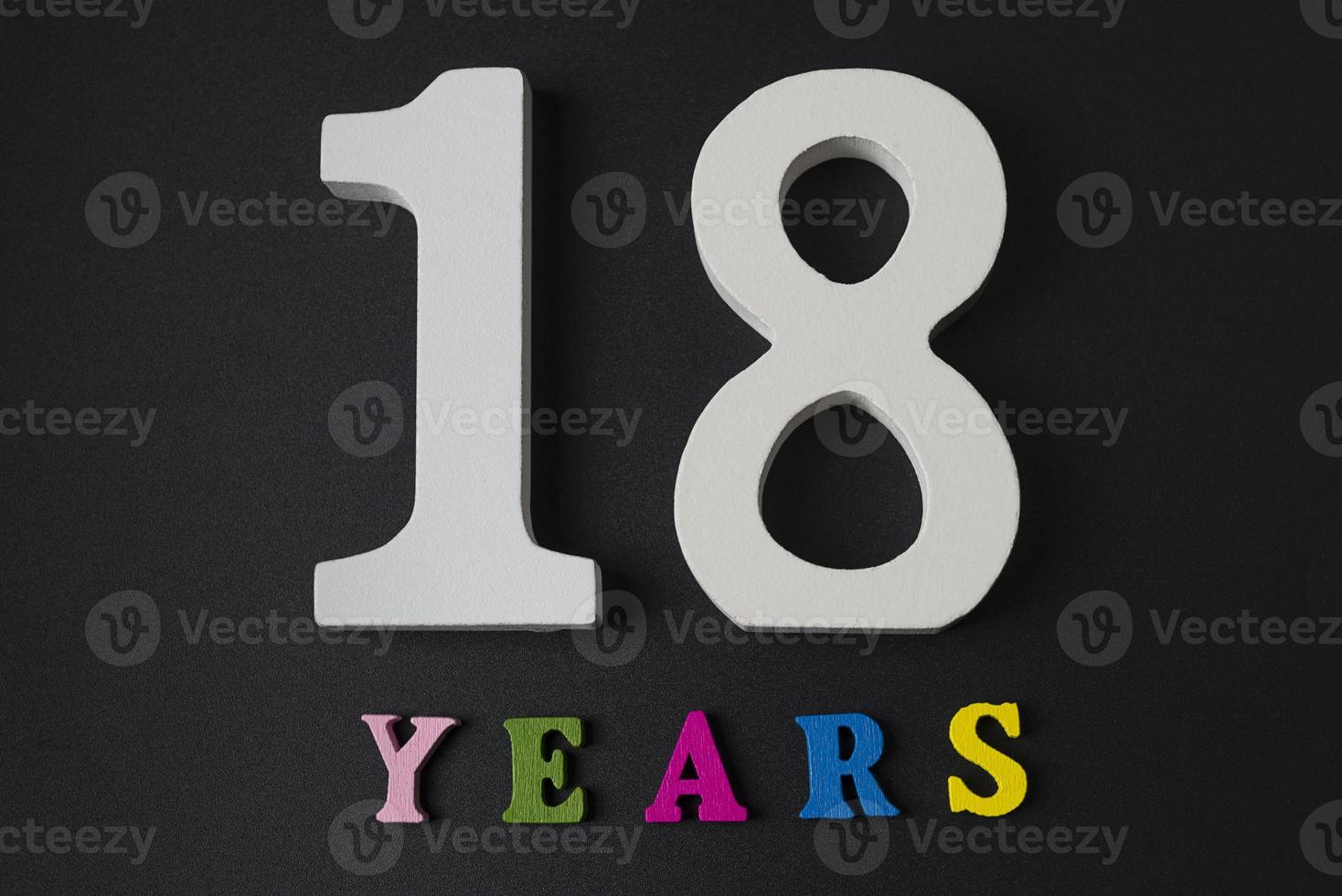 Letters and numbers for eighteen years on a black background. photo