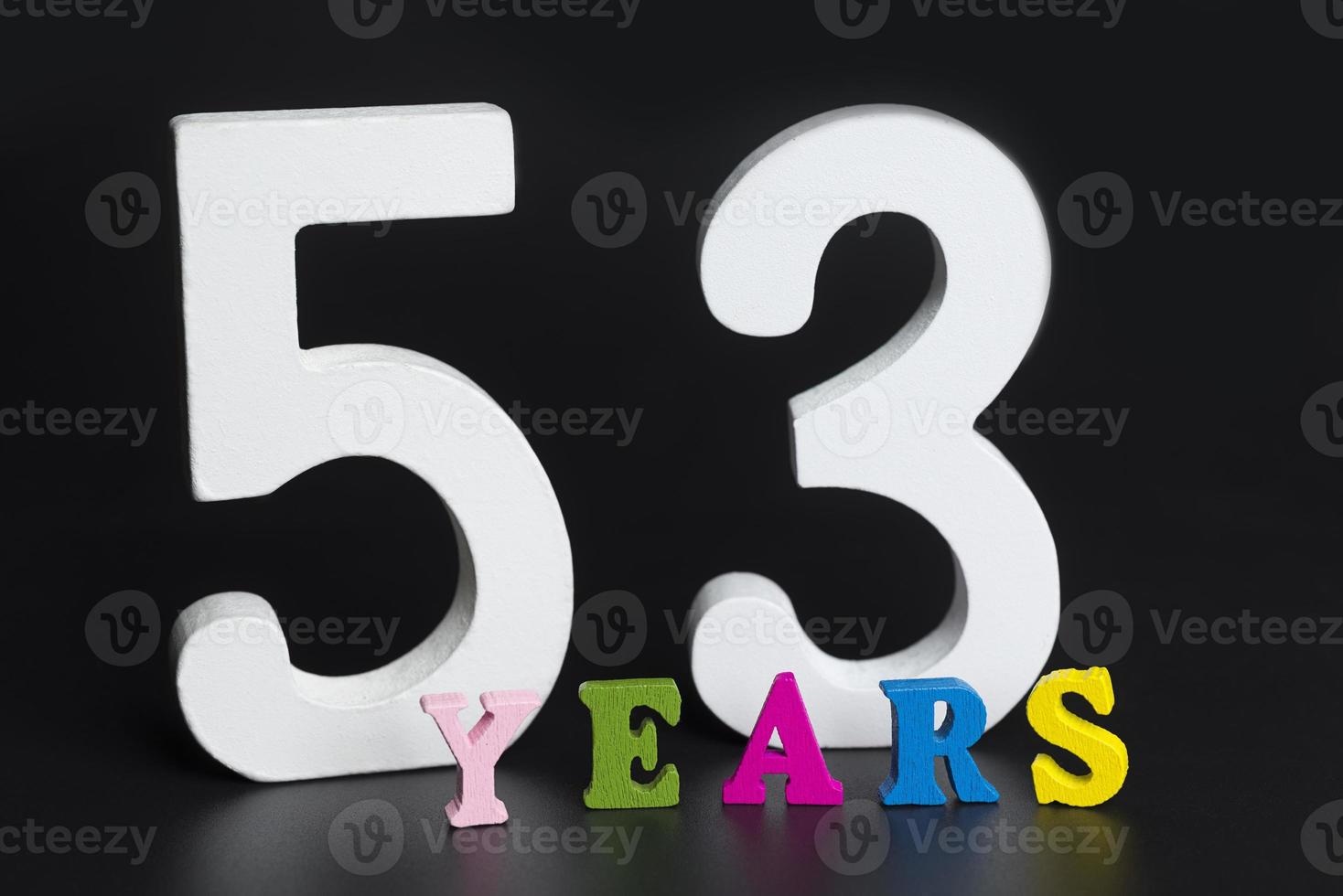 Letters and numbers fifty-three years on a black background. photo