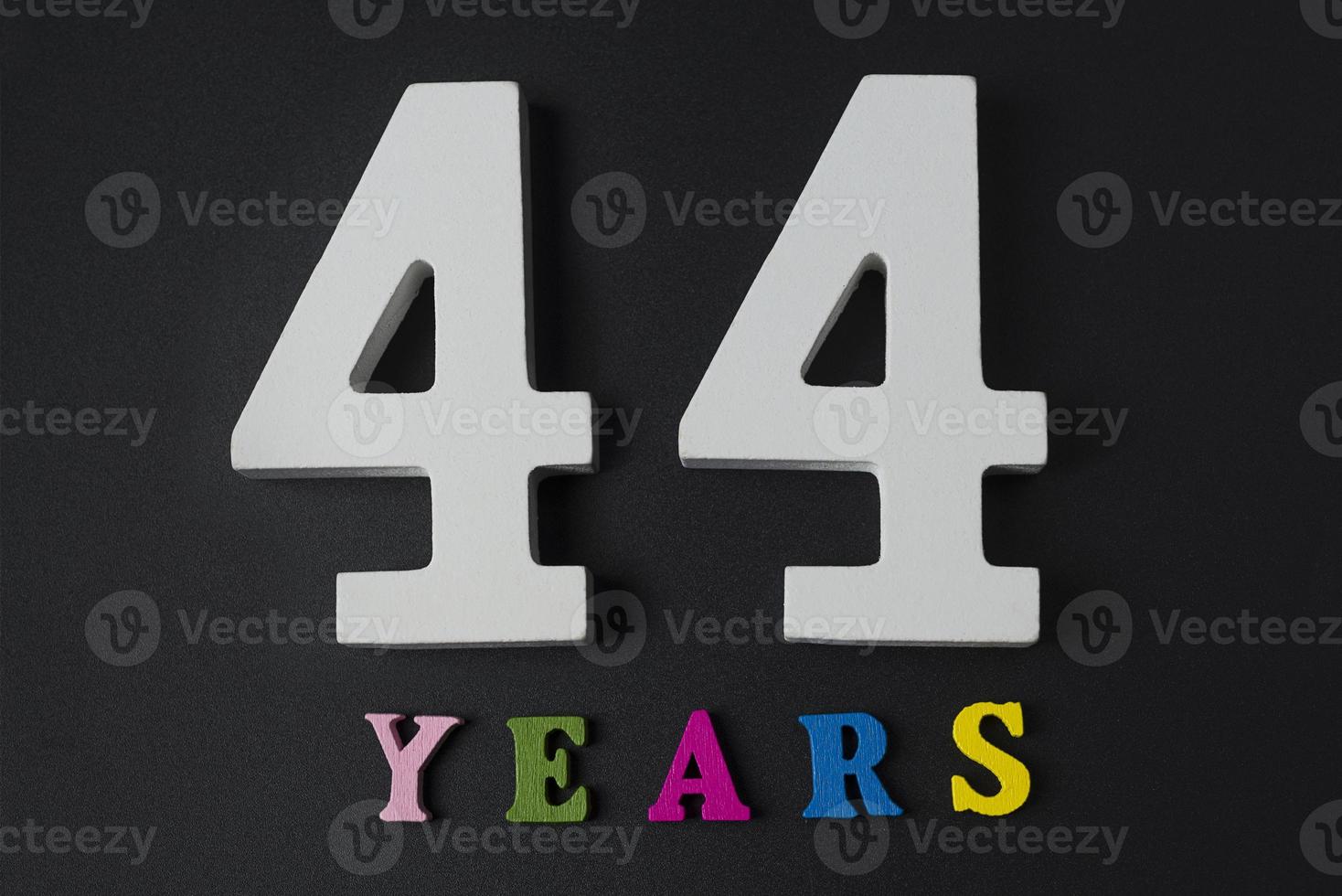 Letters and numbers forty-four years on a black background. photo