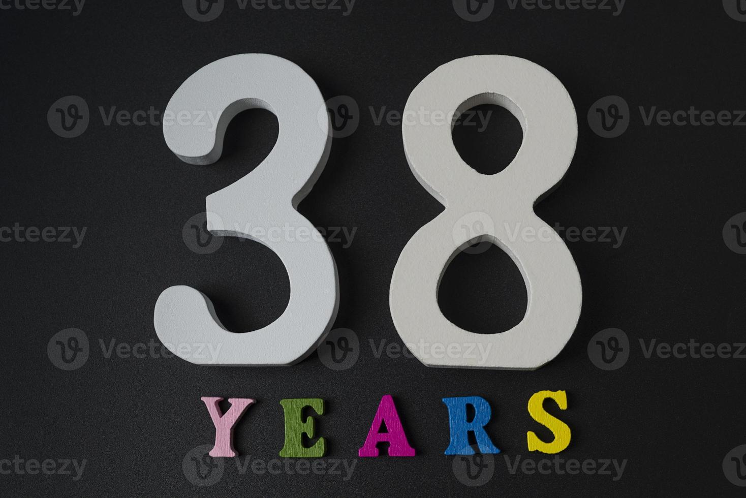 Letters and numbers thirty-eight years on a black background. photo