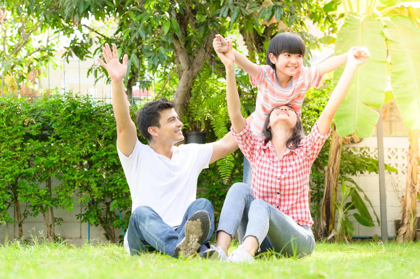 A happy young family spends time playing together in the garden at the front of house the vacation. photo