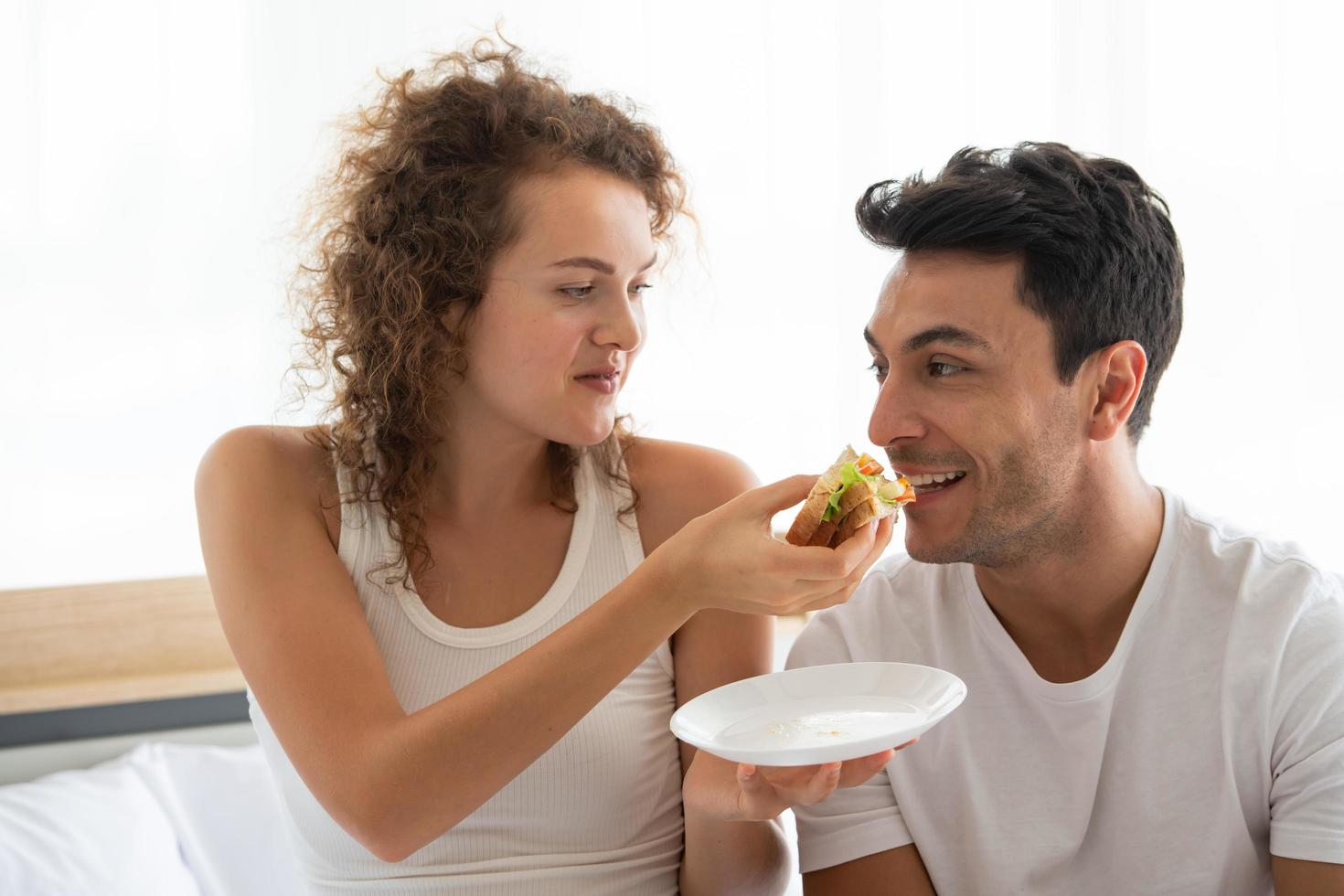 Happy couples relaxing in the white bedroom Of the apartment photo