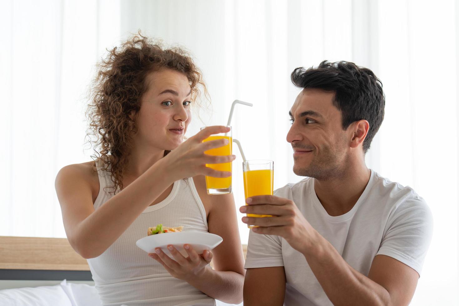 Happy couples relaxing in the white bedroom Of the apartment photo