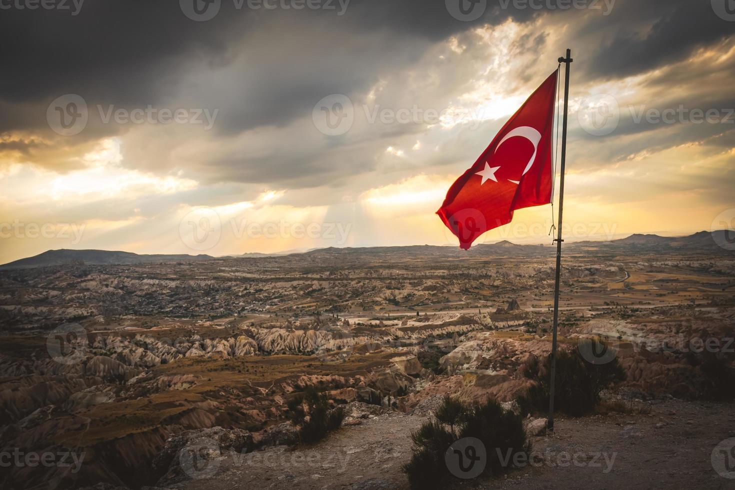 Símbolo nacional de Turquía: bandera turca en el poste en la cima de una colina sobre los valles de Capadocia con un espectacular espacio de copia con nubes foto