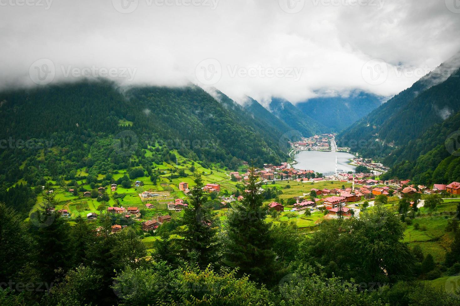 Greenery with stunning mountain lake with turquoise water with beautiful homes in mountains village Uzun Gol in Karadeniz photo