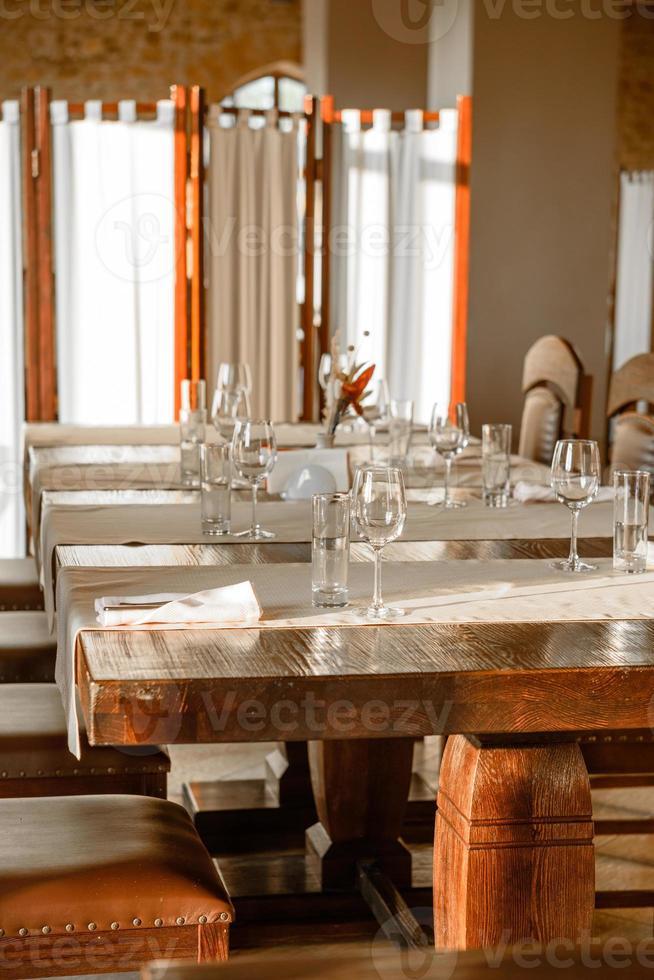 vasos, tenedor de flores, cuchillo servido para cenar en un restaurante con un interior acogedor foto