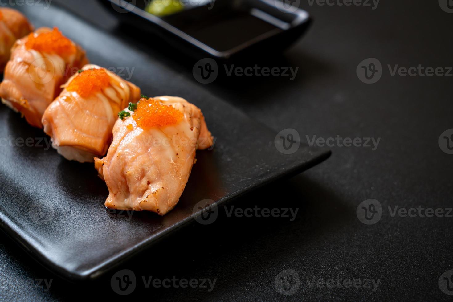 grilled salmon sushi on black plate photo